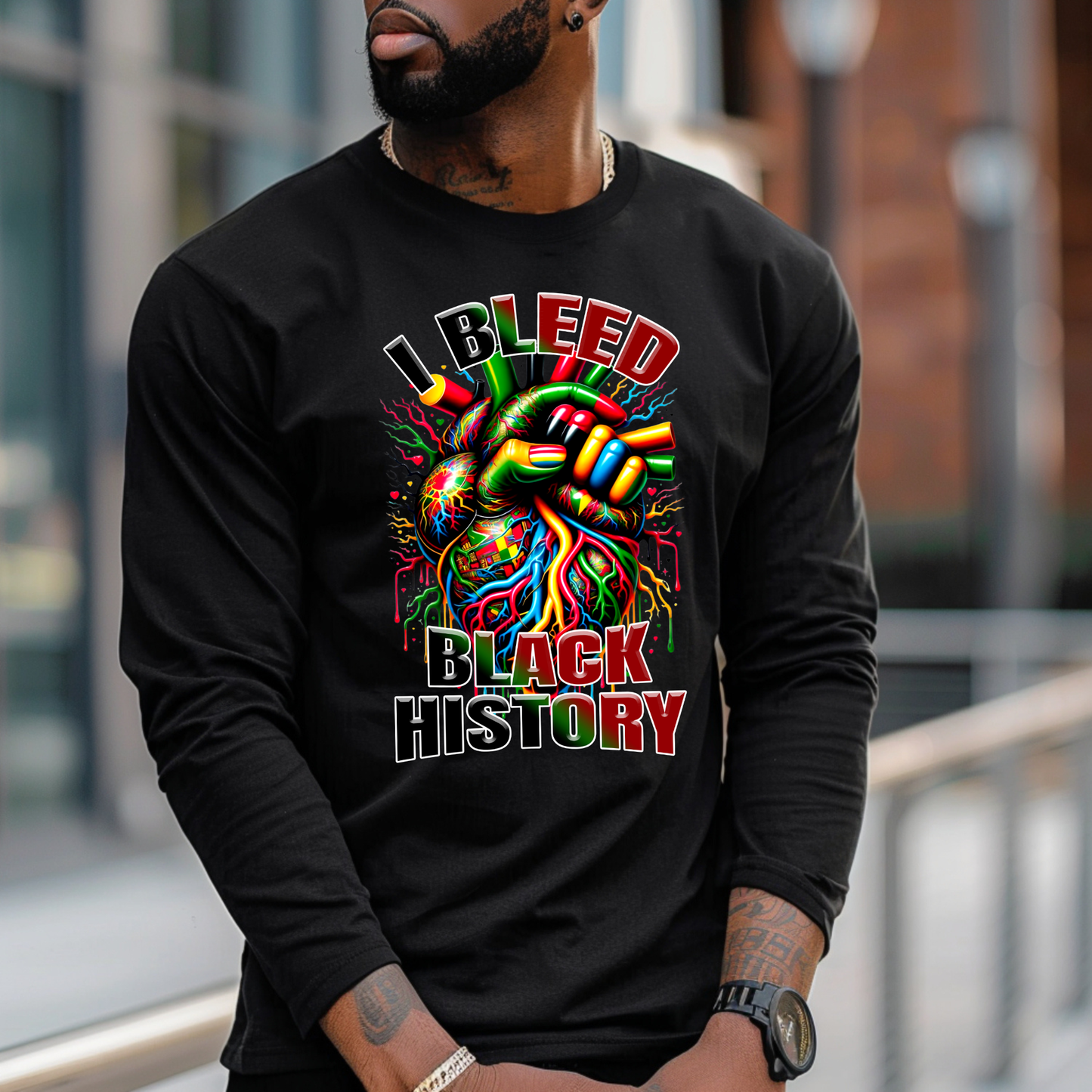 Person wearing a black long-sleeve shirt with a colorful design and text 'I BLEED BLACK HISTORY'.
