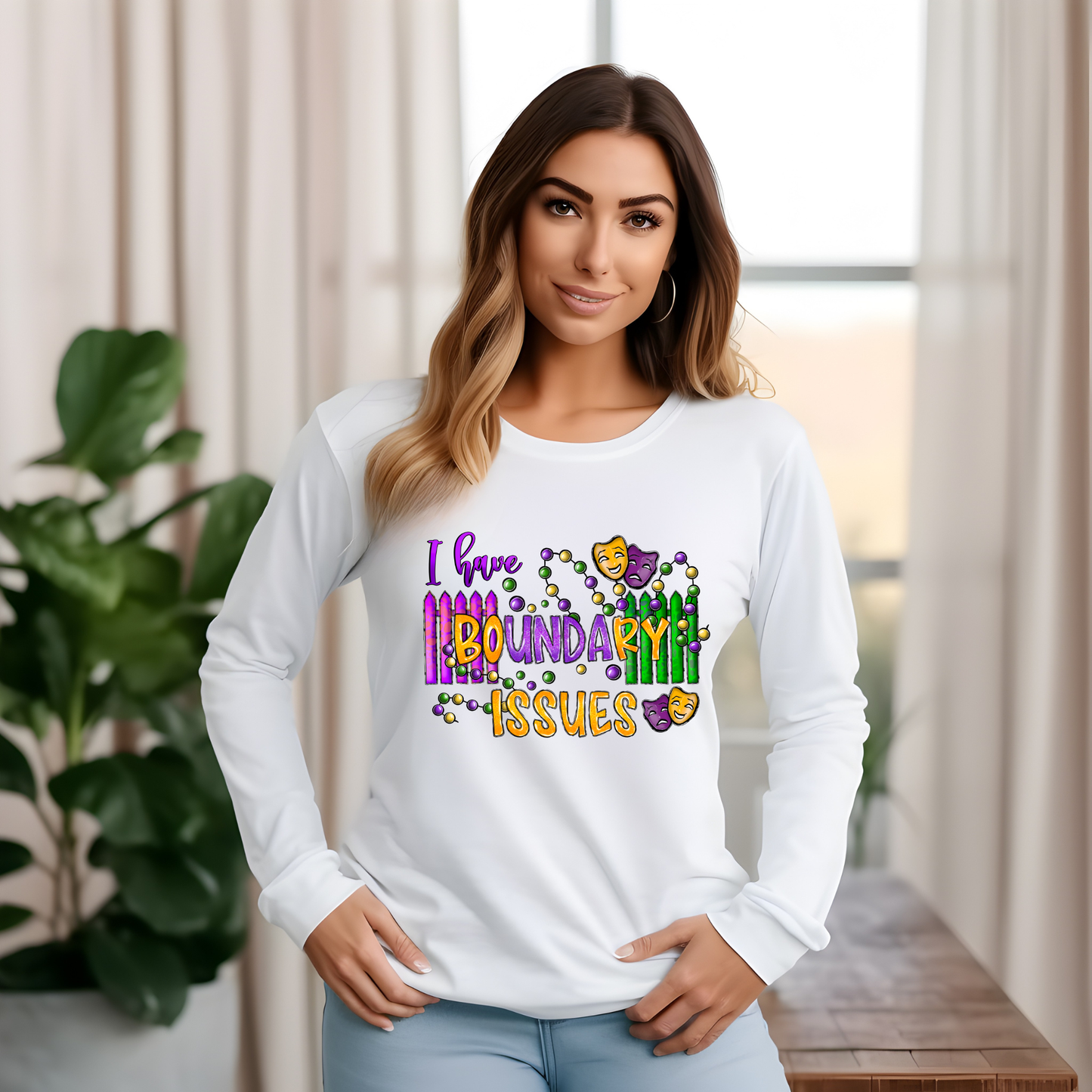 Woman wearing a white long-sleeve shirt with colorful text design in a home setting.