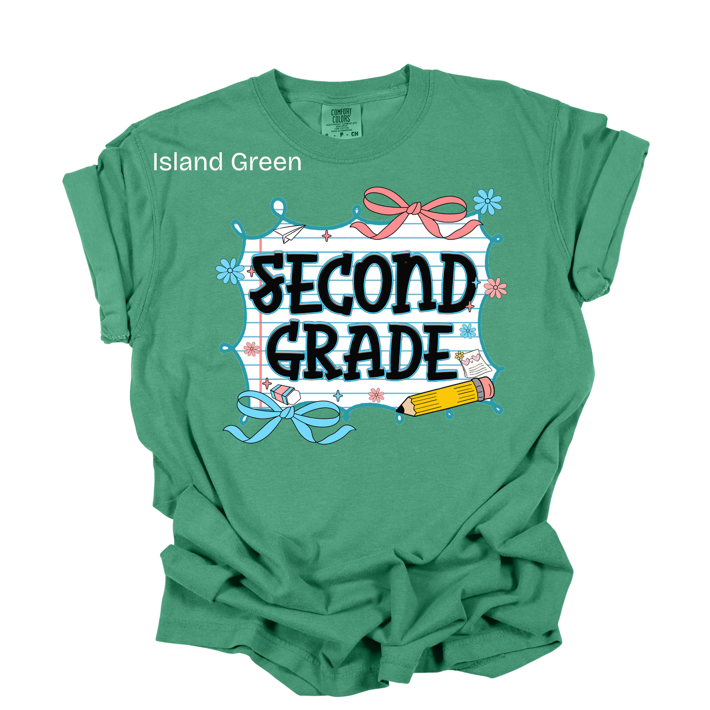A green short-sleeve t-shirt with a 'SECOND GRADE' graphic on the front, featuring school-themed illustrations like a pencil, ribbon, and chalkboard. The text 'Island Green' is printed near the left shoulder.