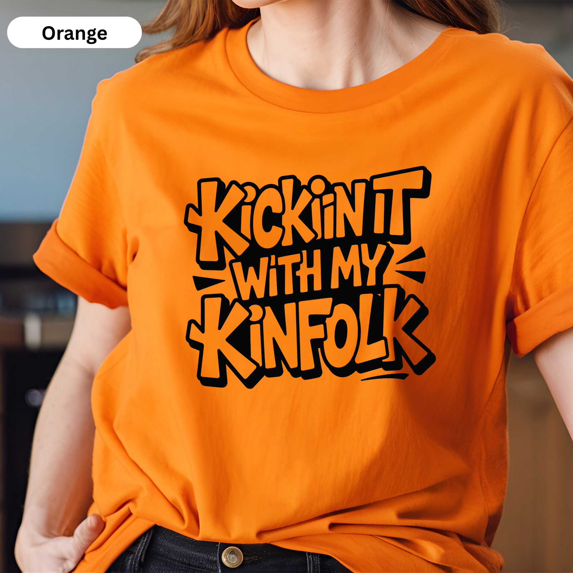 Person wearing an orange t-shirt with black text design.