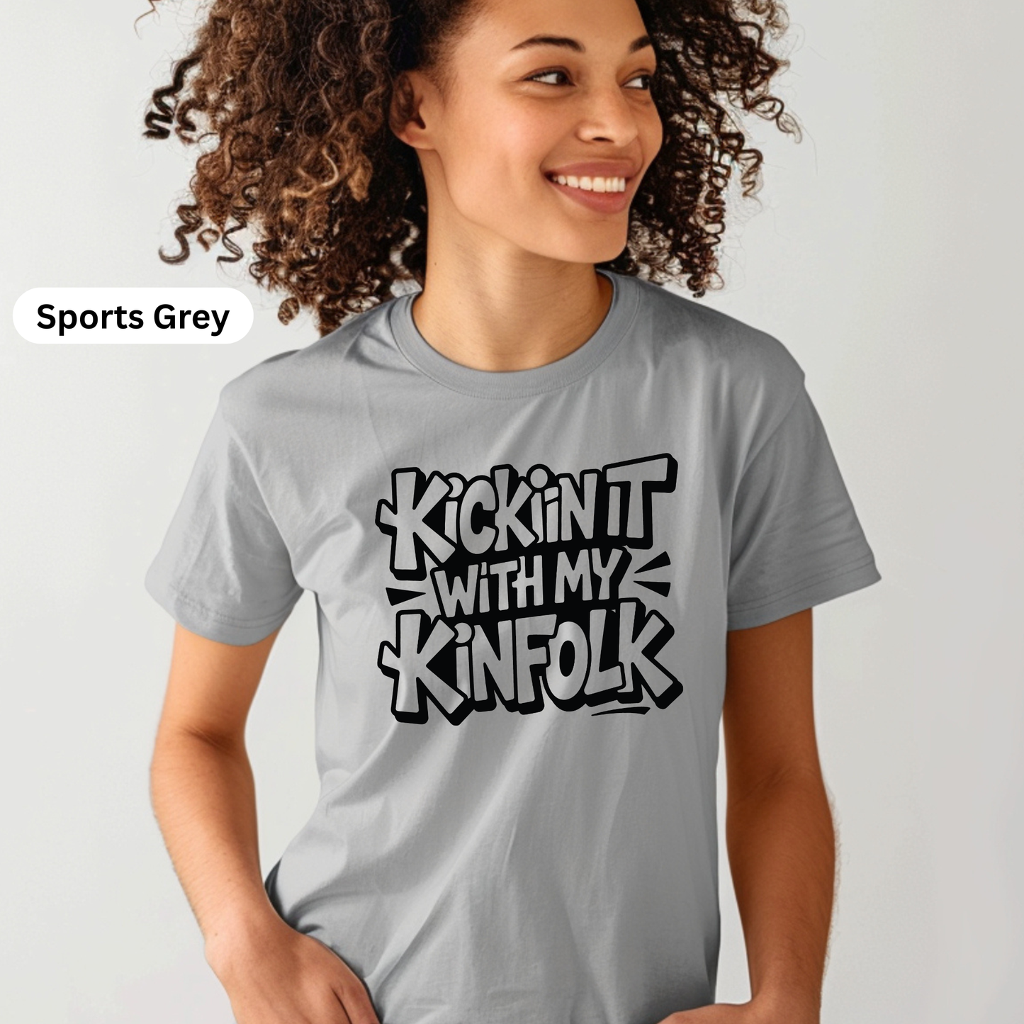 Person wearing a gray t-shirt with text 'Kickin' it with my Kinfolk' on a plain background