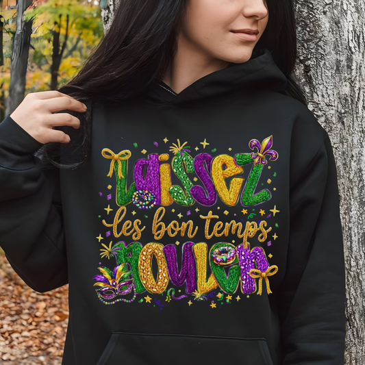 Person wearing a black hoodie with colorful text and designs, standing outdoors.
