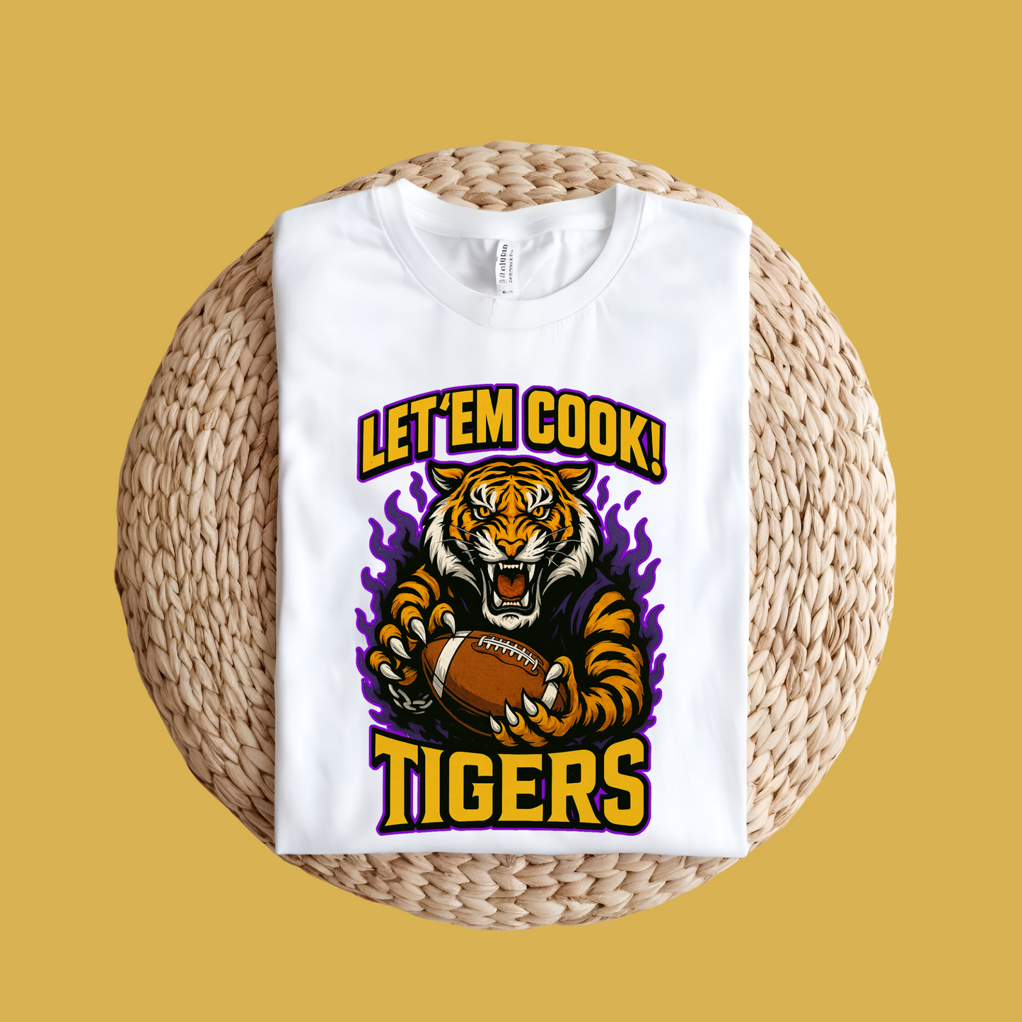 White t-shirt with tiger graphic and 'Let'em Cook! Tigers' text on a woven surface. Let'em Cook Tigers Bold Graphic T-Shirt - Let'Em Cook Tigers Football Tee