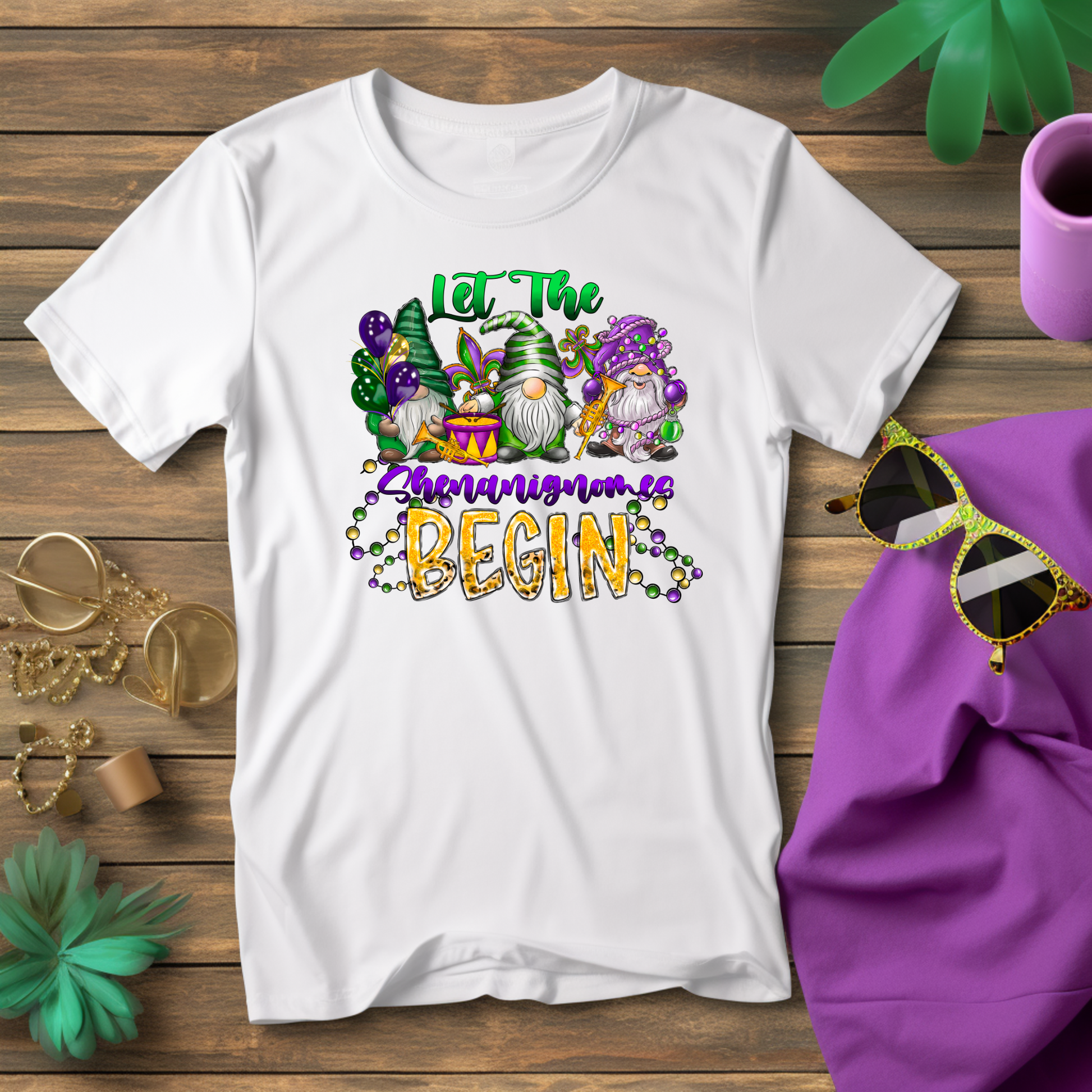 White t-shirt with gnome-themed design and text on a wooden surface with accessories.