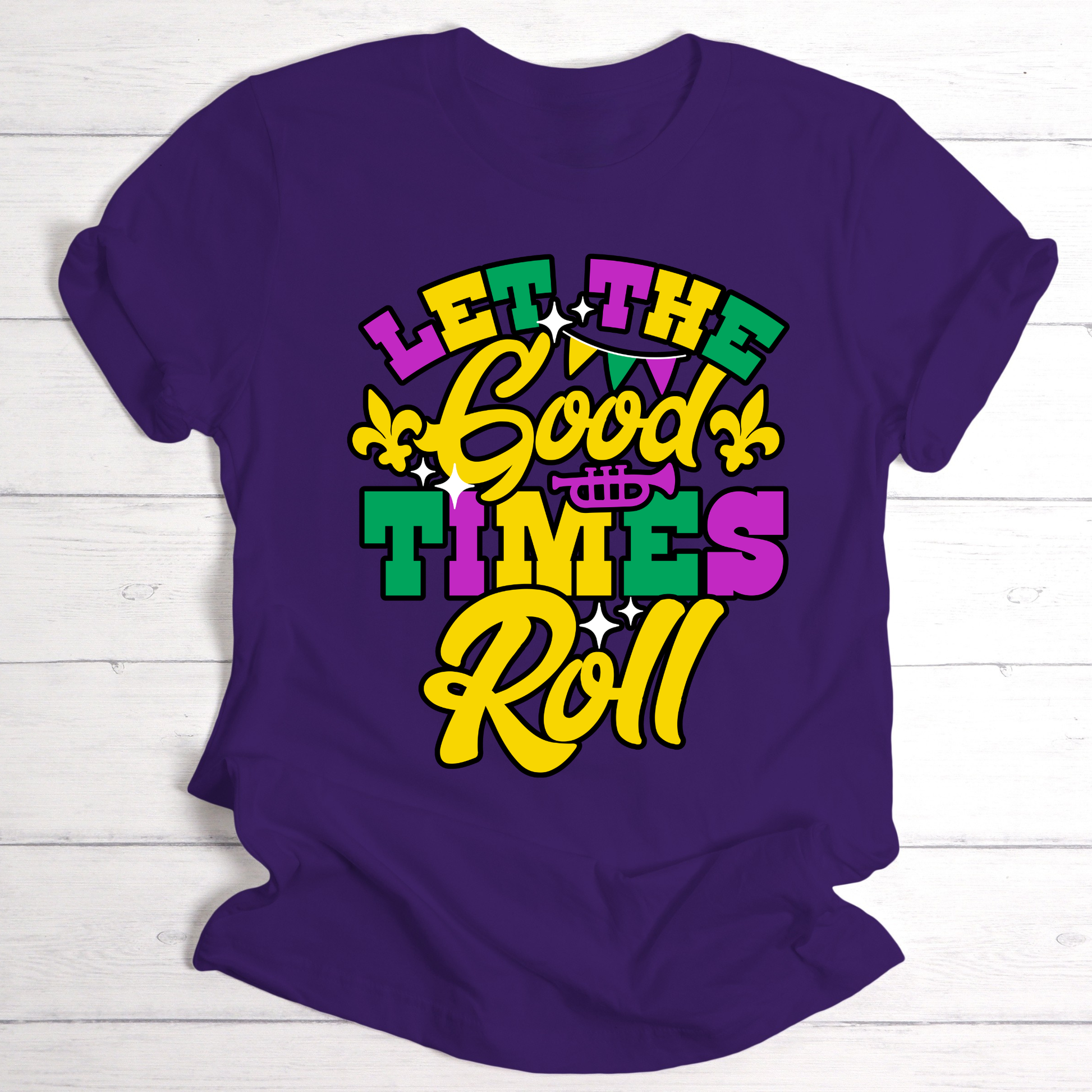 Purple t-shirt with colorful 'Let the Good Times Roll' text on a white wooden background