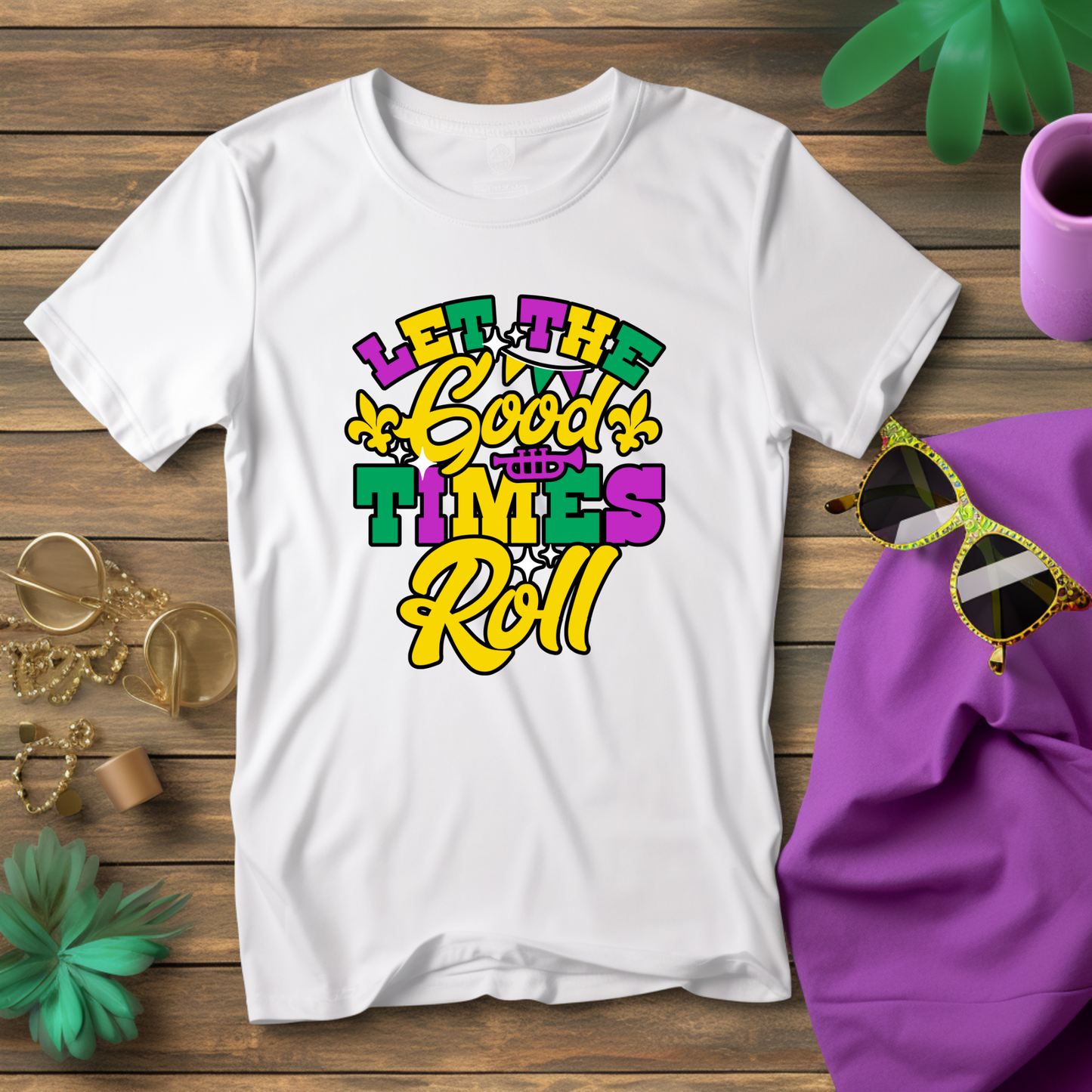 White t-shirt with colorful text design on a wooden surface with accessories.