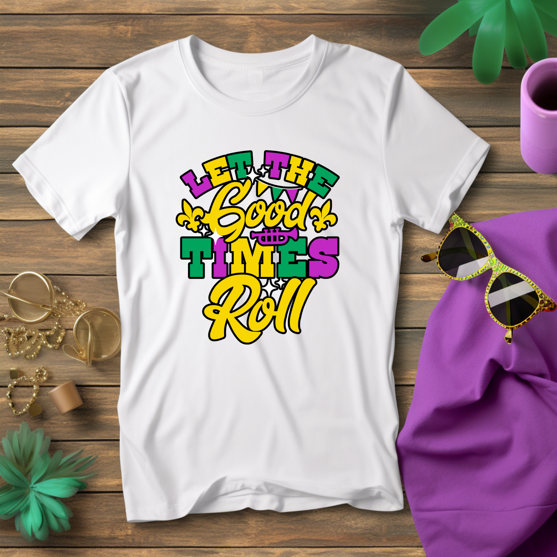 White t-shirt with colorful text design on a wooden surface with accessories.