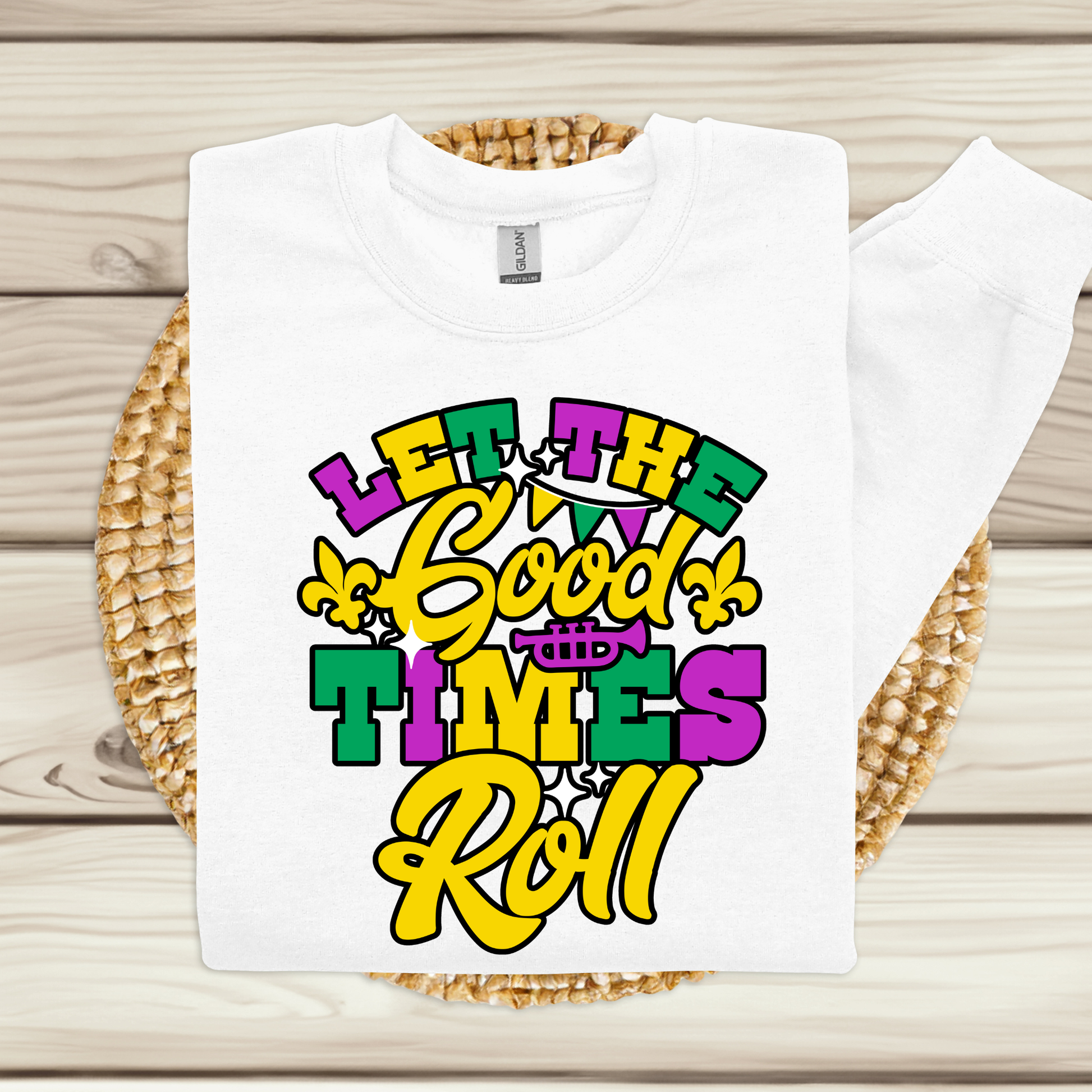 White t-shirt with colorful 'Let the Good Times Roll' text design on a woven mat.