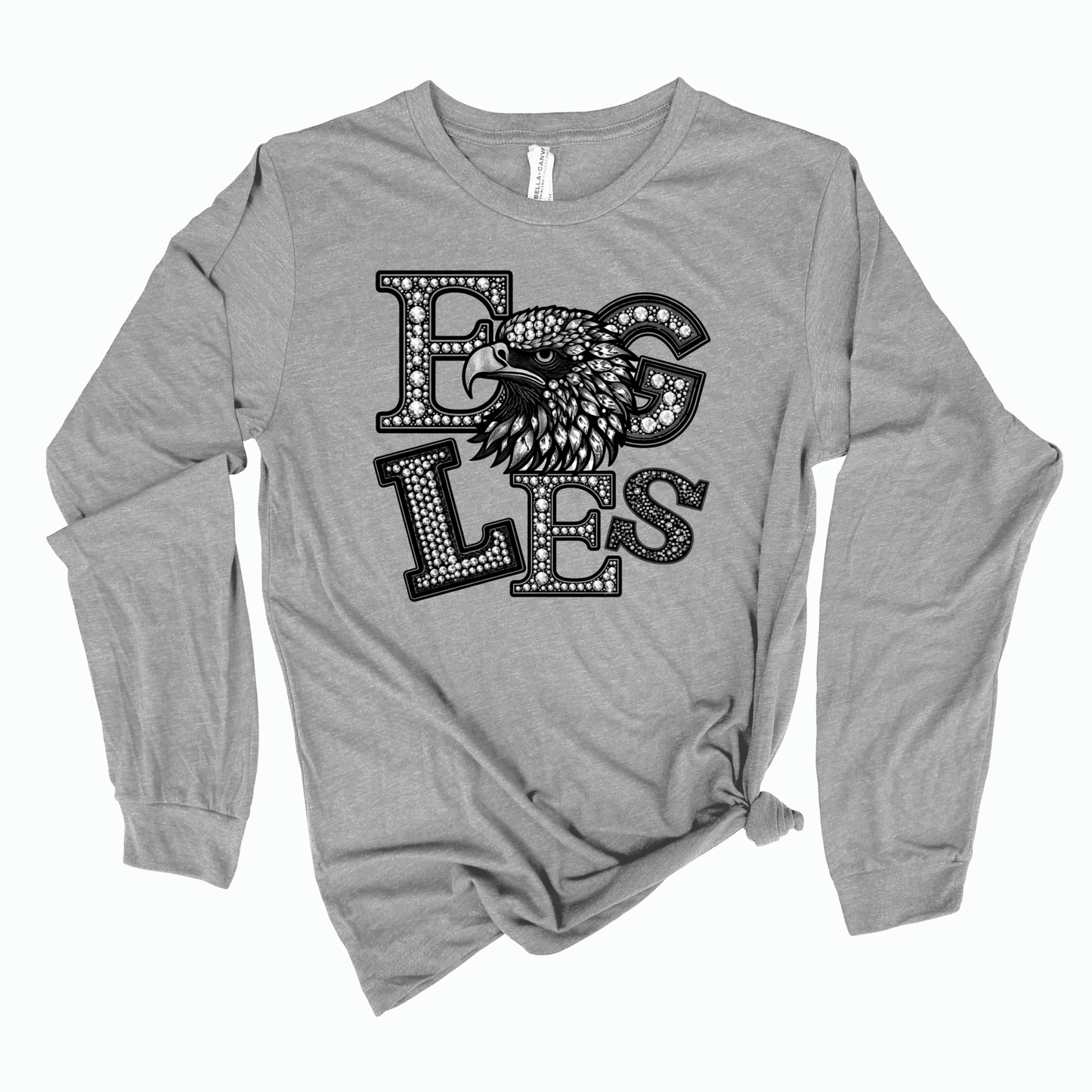 A heather gray long-sleeve t-shirt with a distressed black graphic on the front that reads 'EGGS' with an eagle head illustration, styled with a knot at the bottom hem, on a white background.
