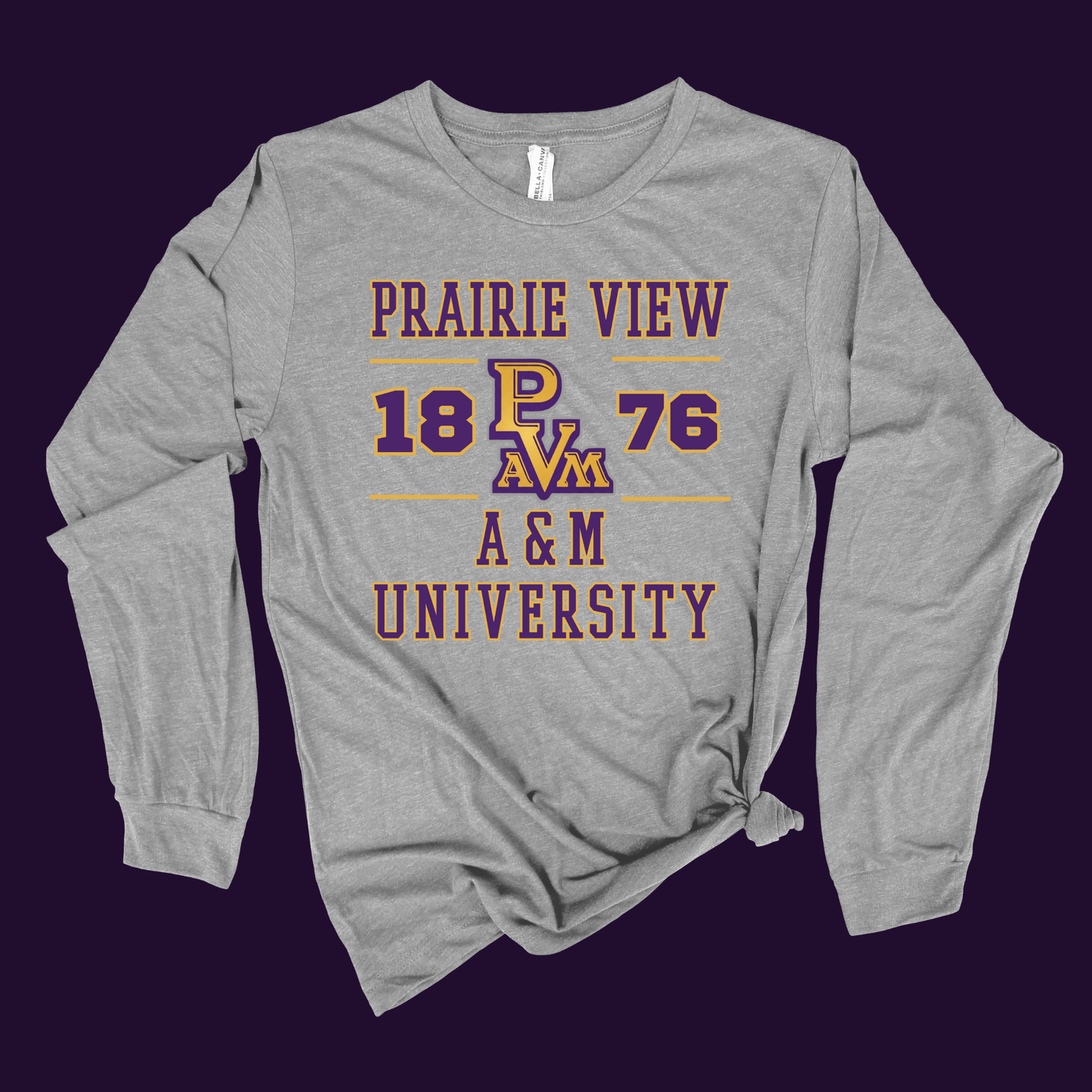 A heather gray long-sleeve t-shirt with a distressed purple and gold graphic reading 'PRAIRIE VIEW 18 PAV 76 A&M UNIVERSITY', shown flat against a dark purple background.