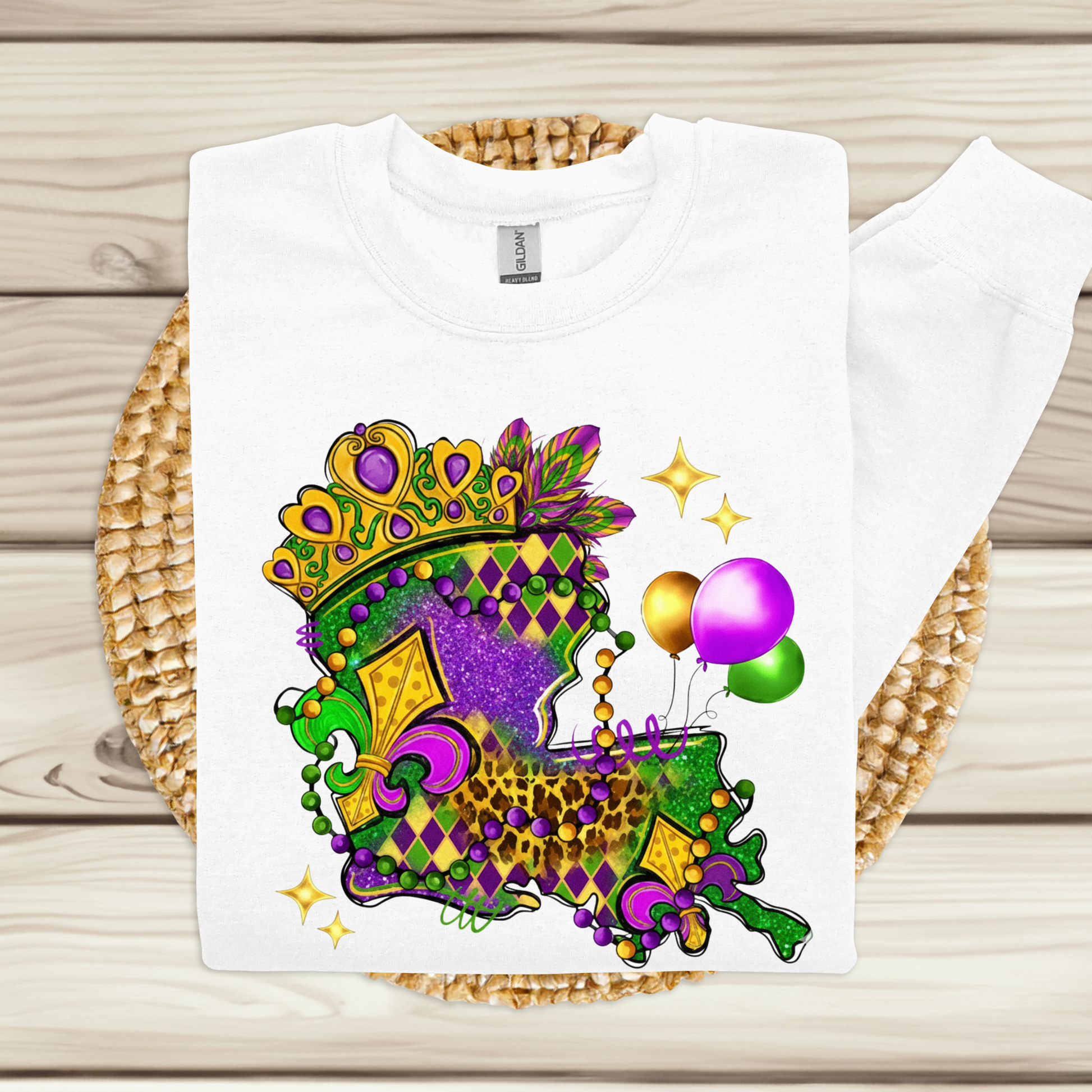 White t-shirt with Mardi Gras-themed design on a woven mat