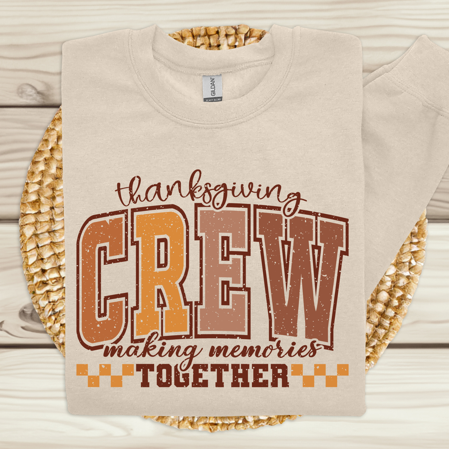 Beige sweatshirt with 'Thanksgiving Crew making memories together' text on a woven mat background