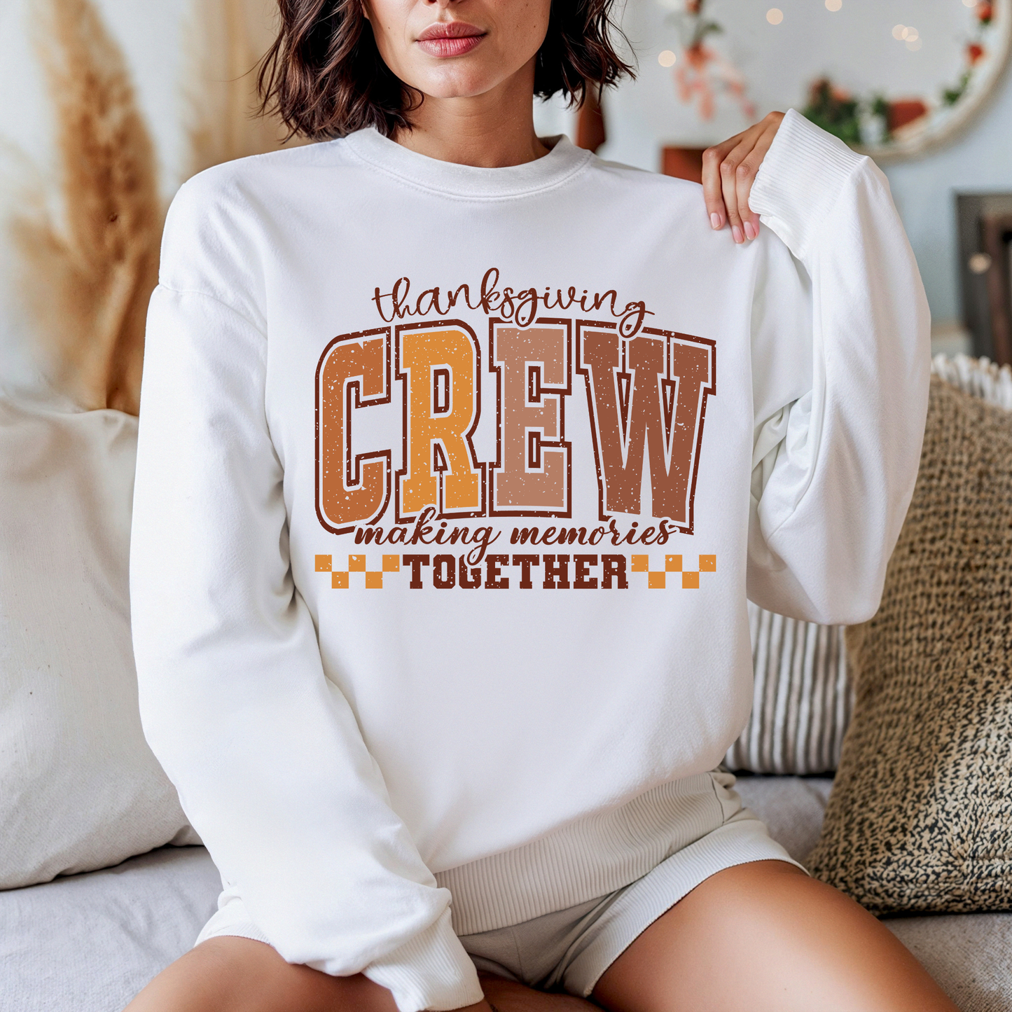 Person wearing a white sweatshirt with 'Thanksgiving CREW making memories Together' text.