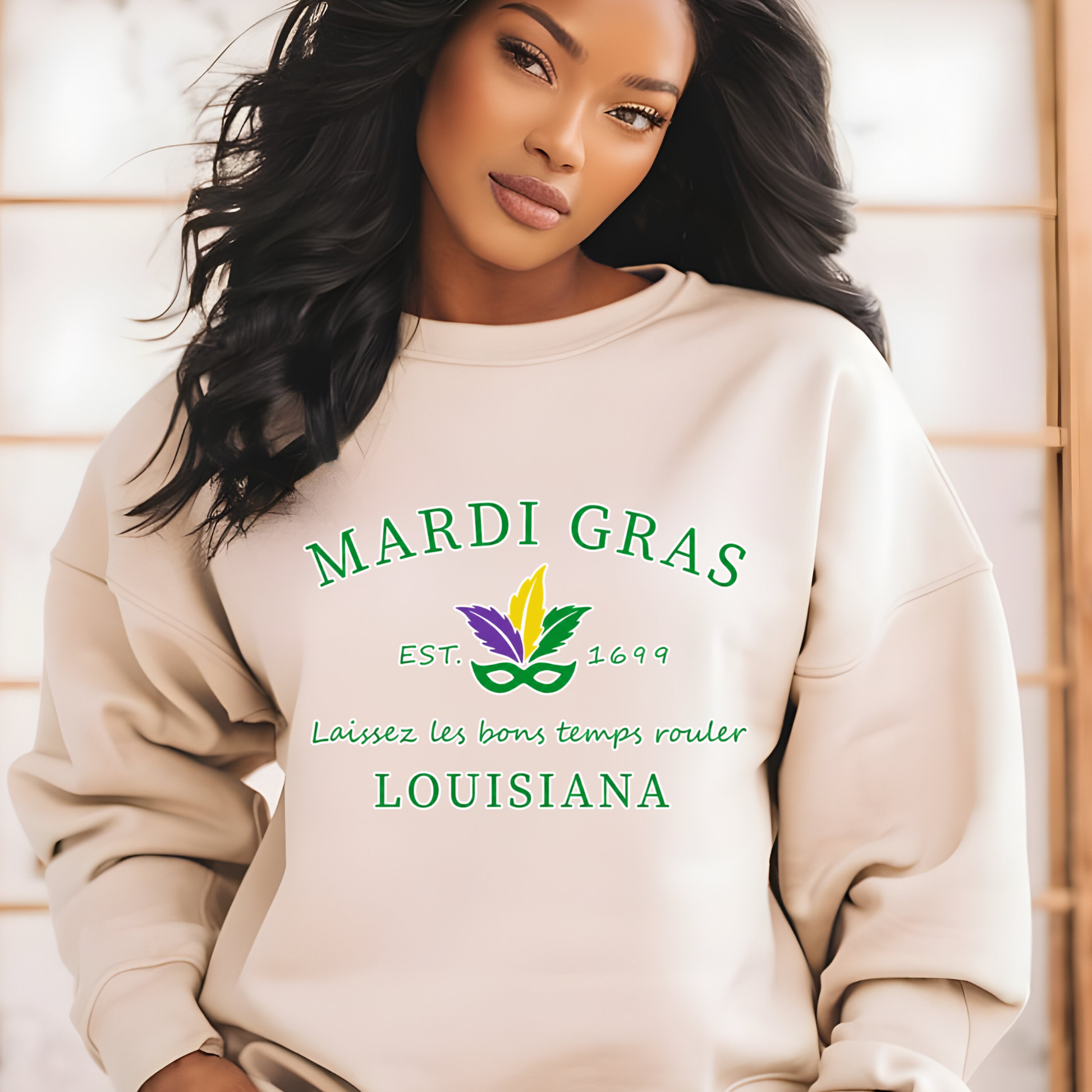 Woman wearing a beige sweatshirt with Mardi Gras-themed text and graphics.