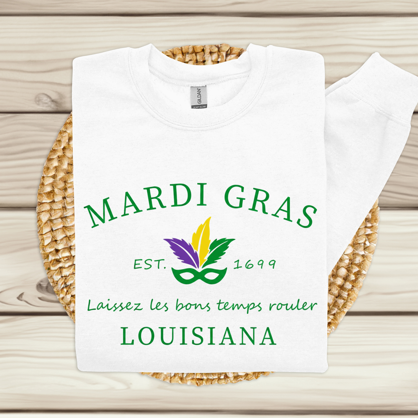 White t-shirt with Mardi Gras-themed design on a woven mat