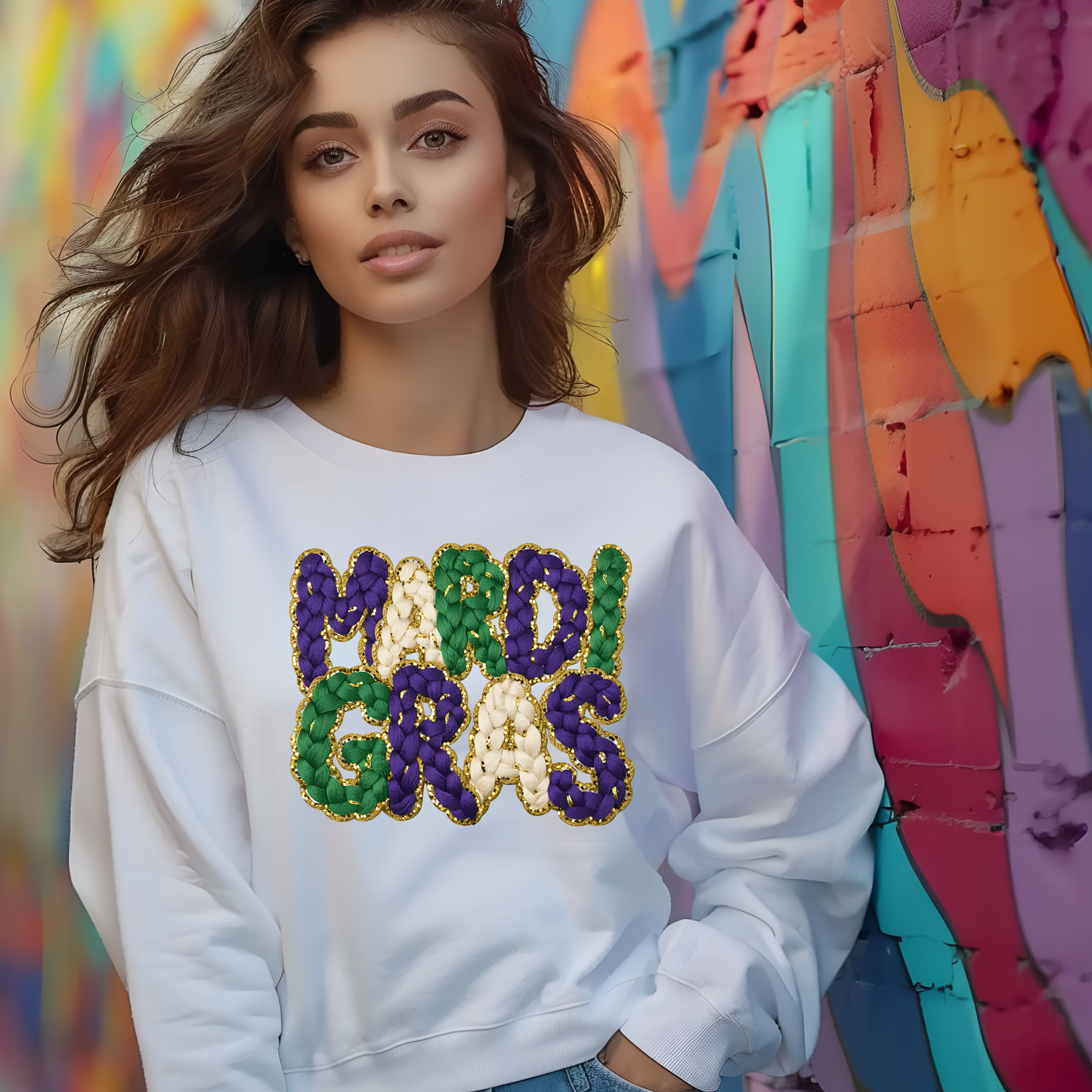 Woman wearing a white sweatshirt with 'MARDI GRAS' in colorful letters against a vibrant, abstract background.