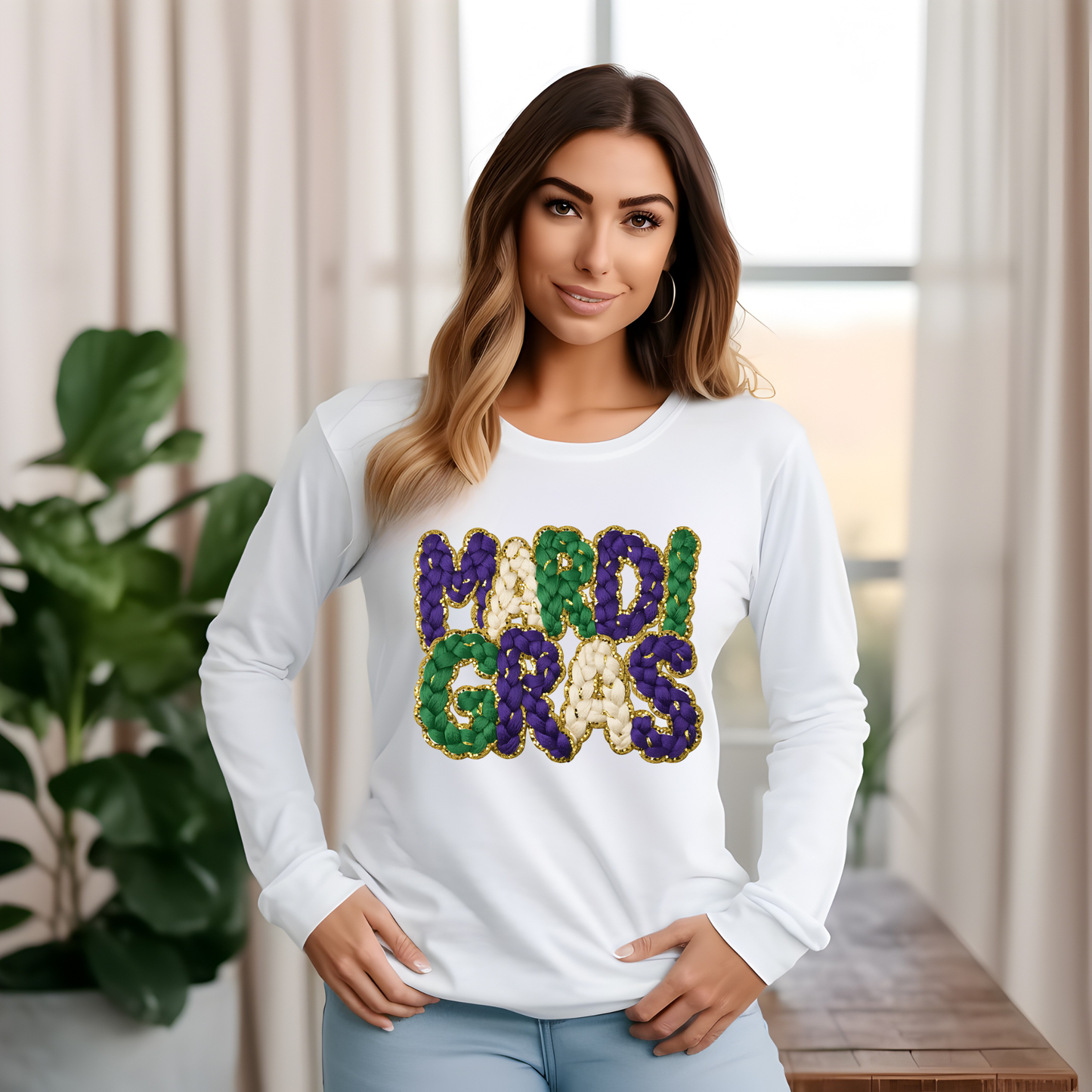 Woman wearing a white long-sleeve shirt with 'MARDI GRAS' in colorful letters, standing indoors.