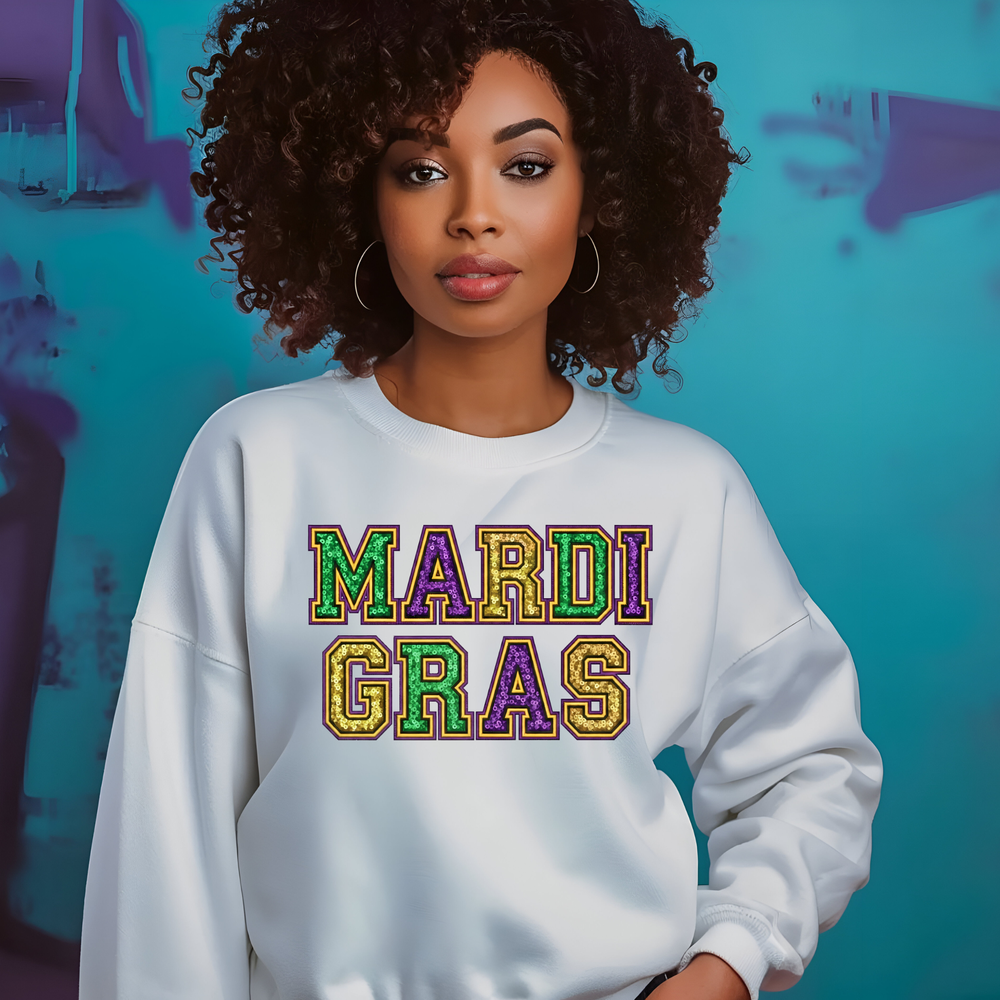Person wearing a white sweatshirt with 'MARDI GRAS' in colorful letters against a blue background.