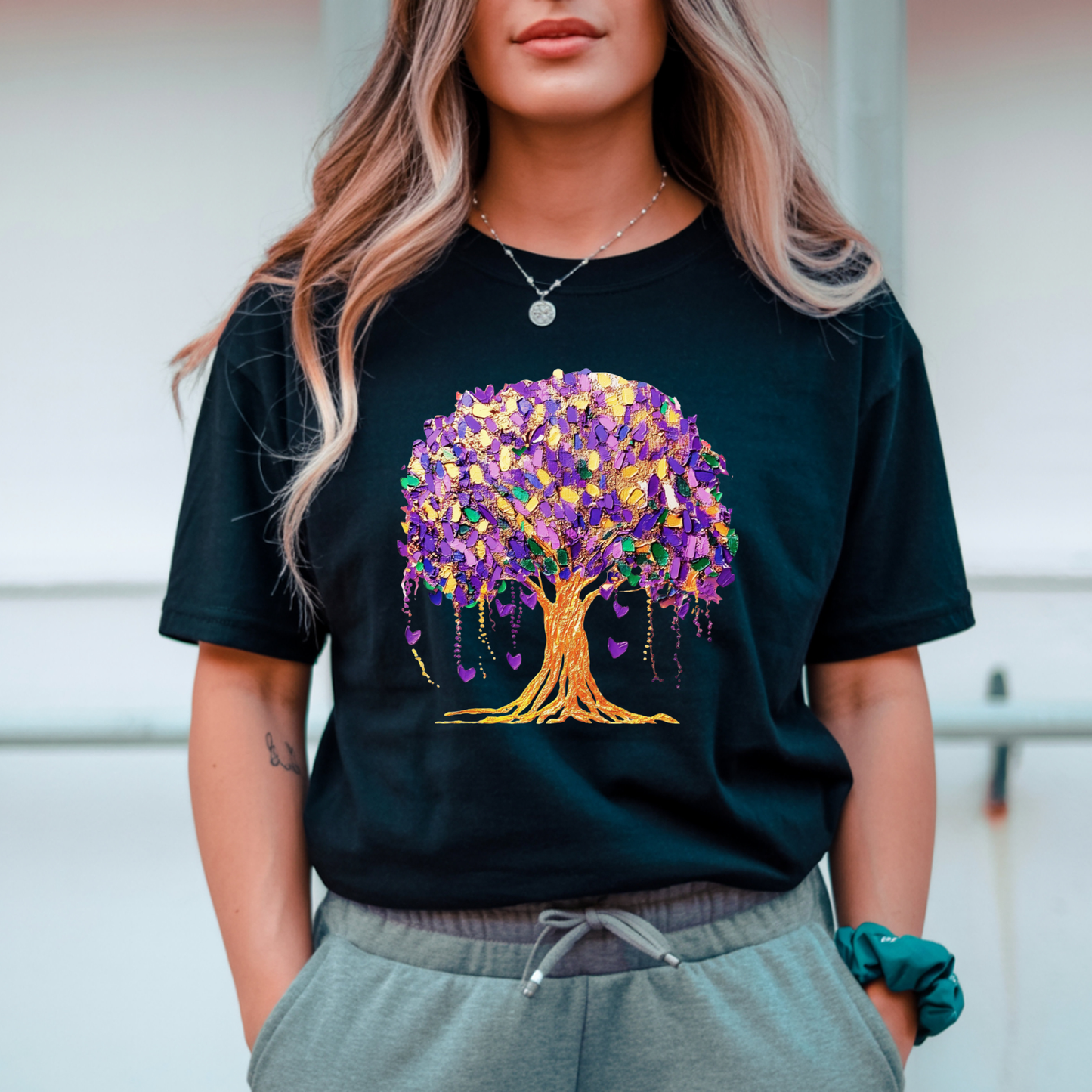 Person wearing a black t-shirt with a colorful tree design.