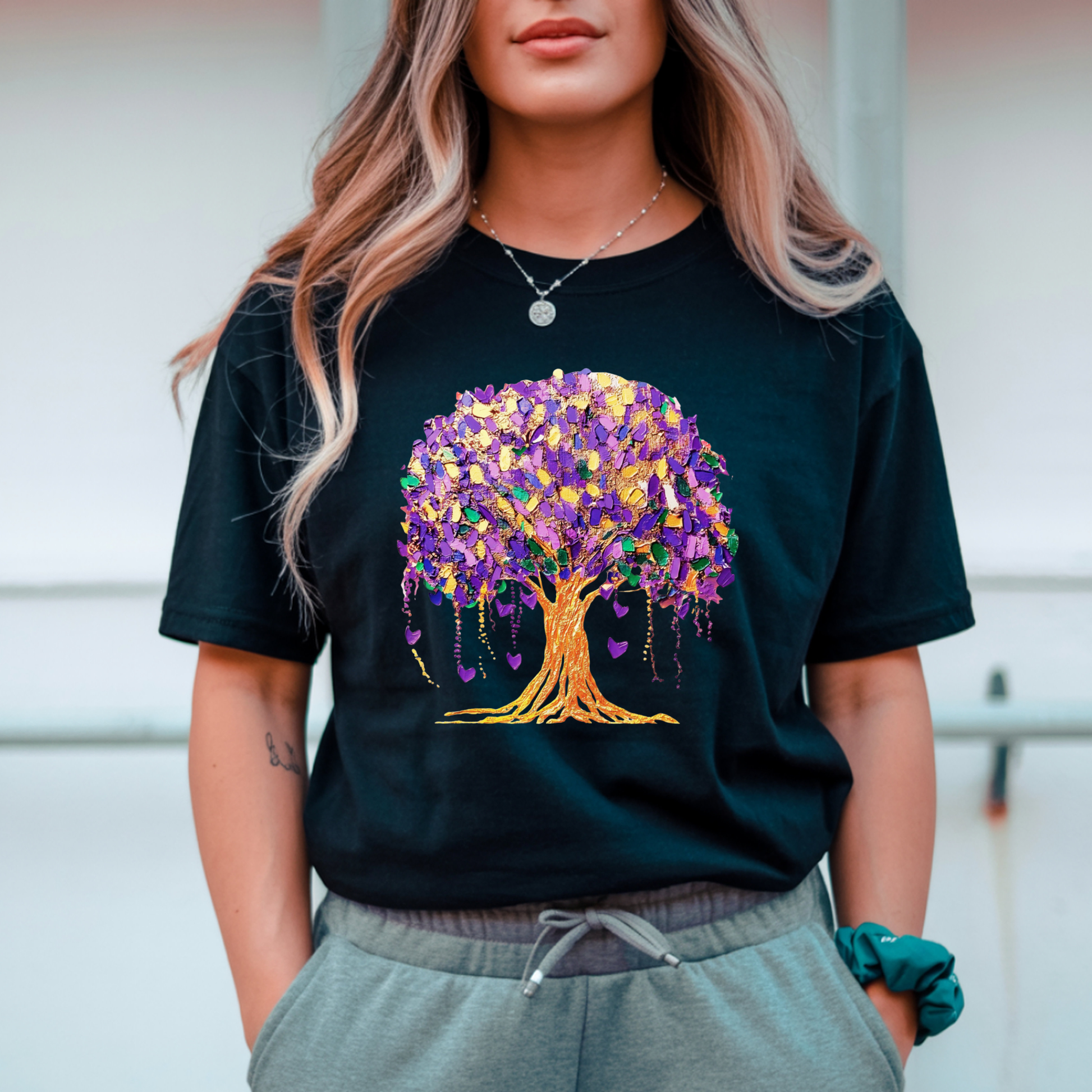 Person wearing a black t-shirt with a colorful tree design.