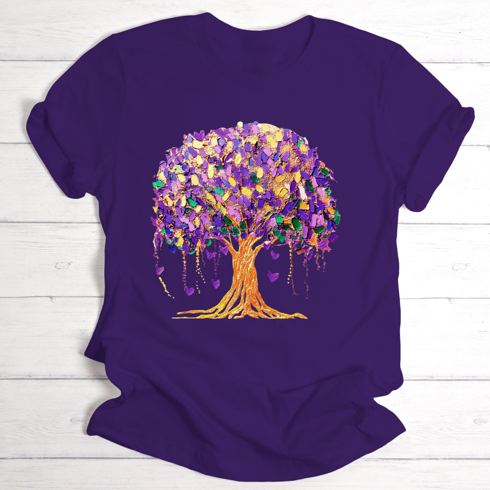 Purple t-shirt with a colorful tree design on a wooden surface