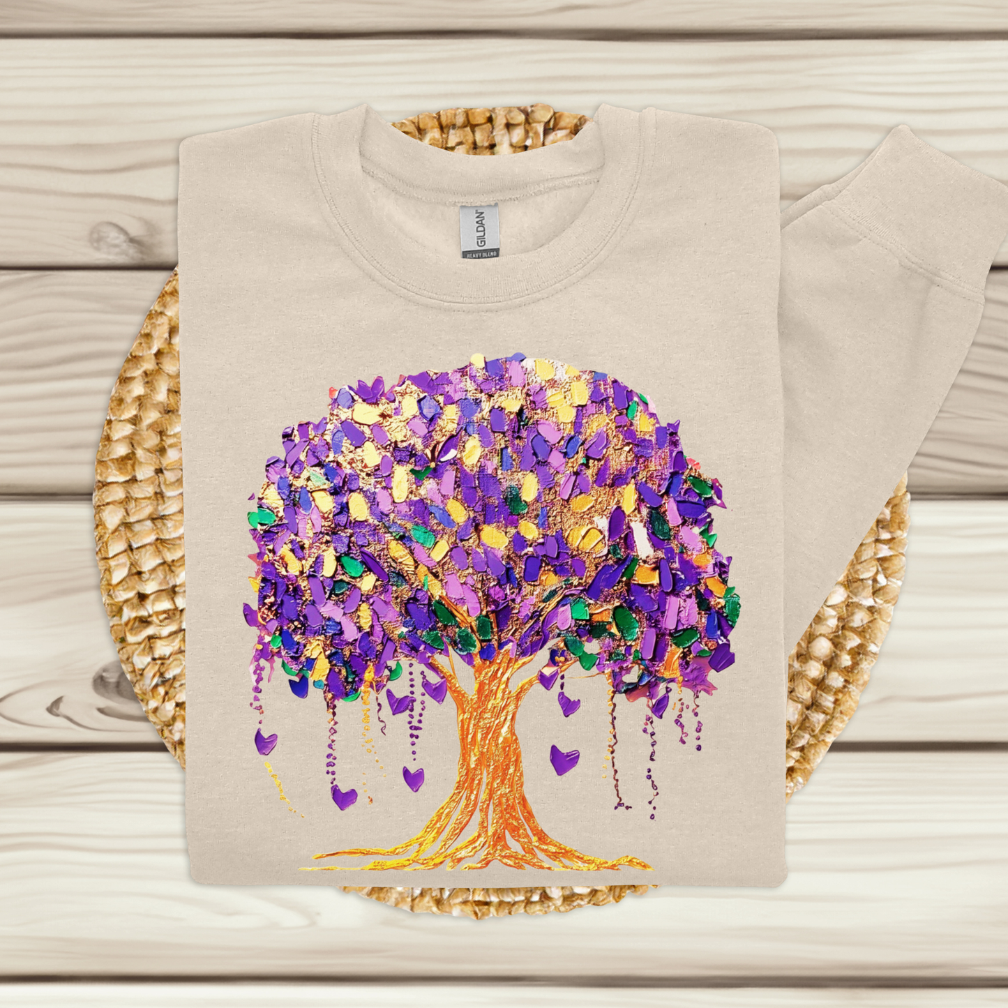 Beige sweatshirt with a colorful tree design on a wooden surface