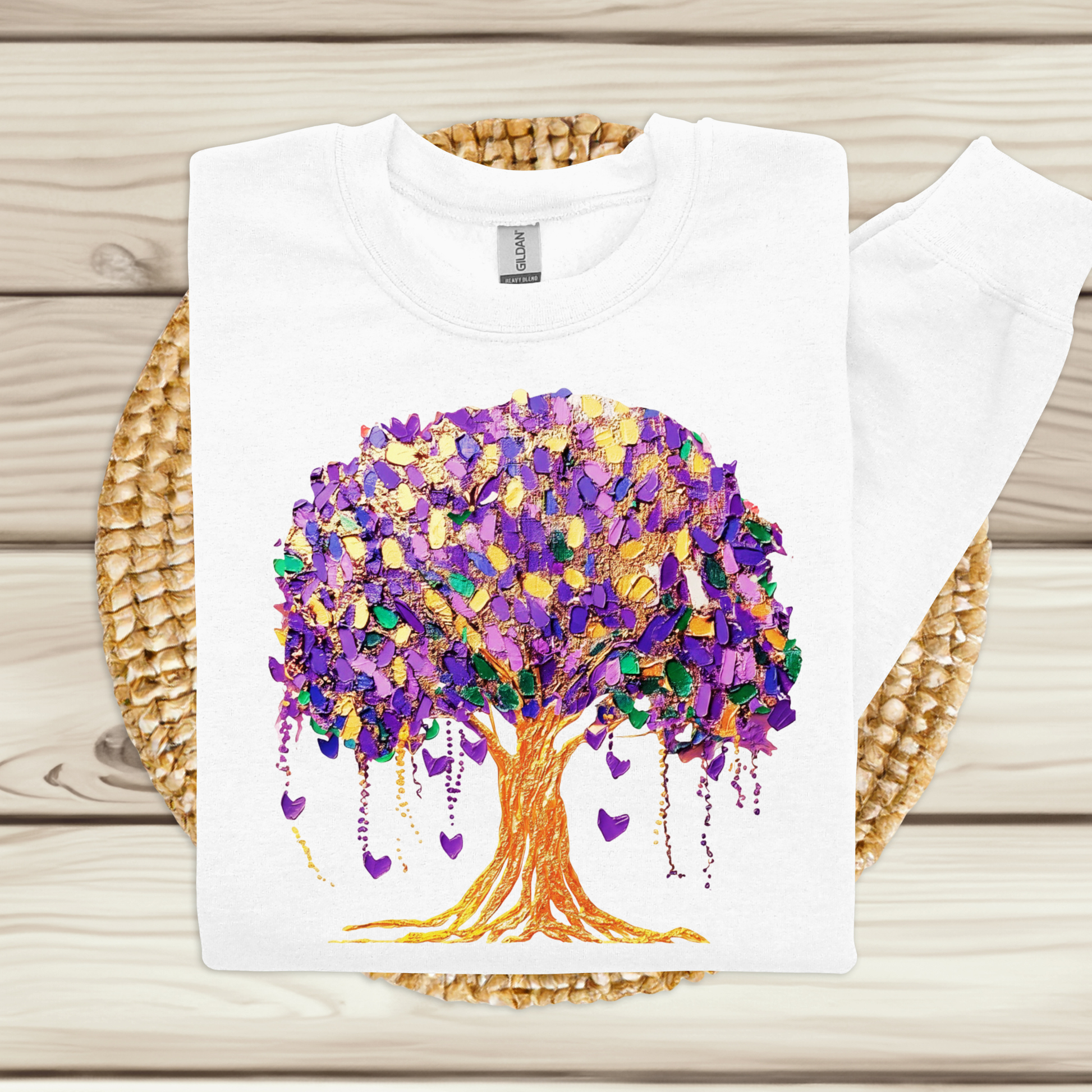 White t-shirt with a colorful tree design on a wooden surface