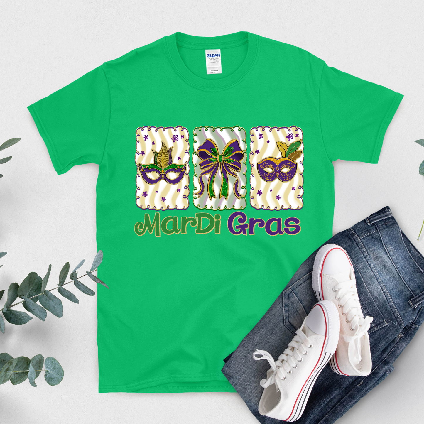 Green t-shirt with Mardi Gras-themed design on a white background