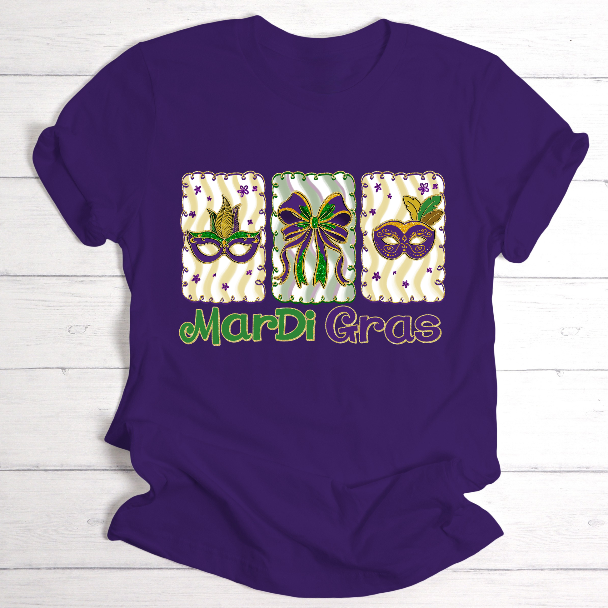 Purple t-shirt with Mardi Gras-themed graphics and text on a wooden surface