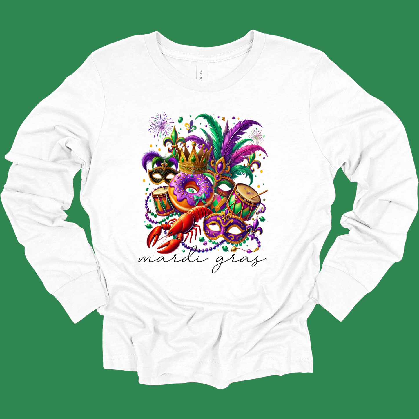 White long-sleeve shirt with Mardi Gras-themed design featuring masks, a crawfish, and drums on a green background.