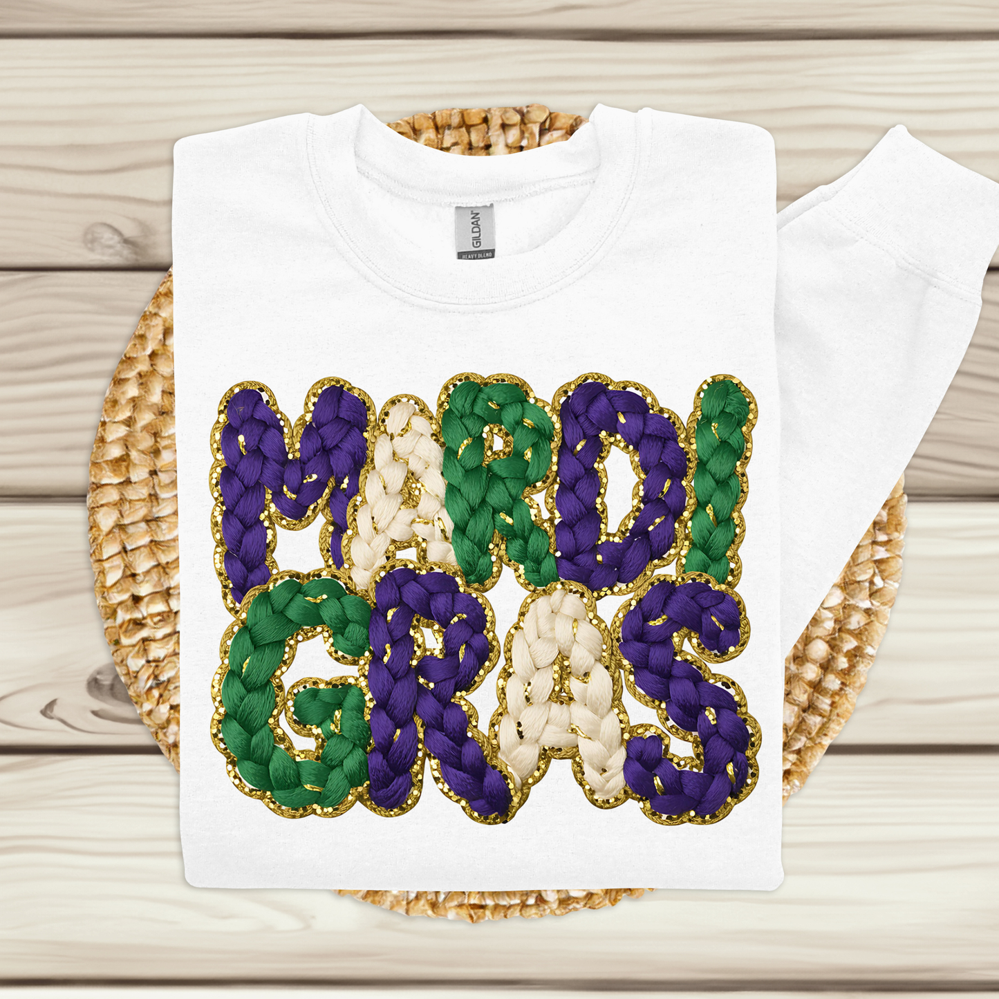 White t-shirt with 'MARDI GRAS' in colorful letters on a woven basket background