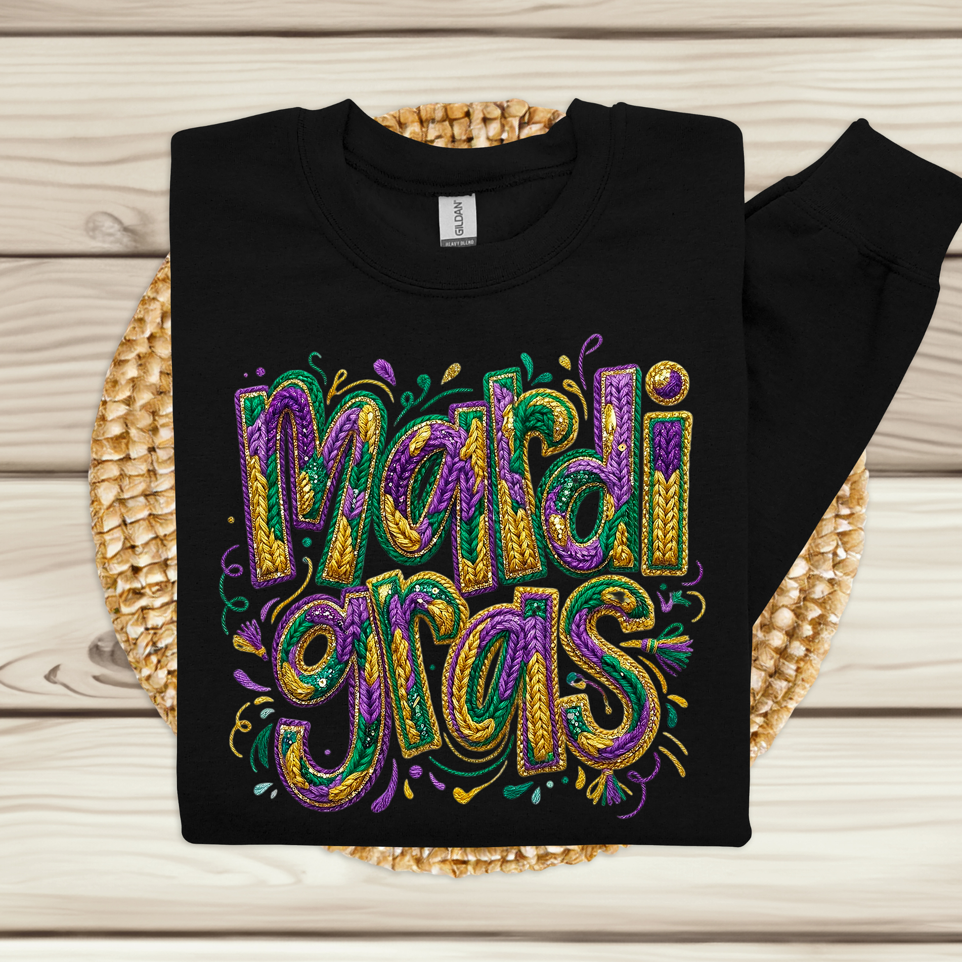 Black sweatshirt with colorful 'Mardi Gras' text on a woven mat.