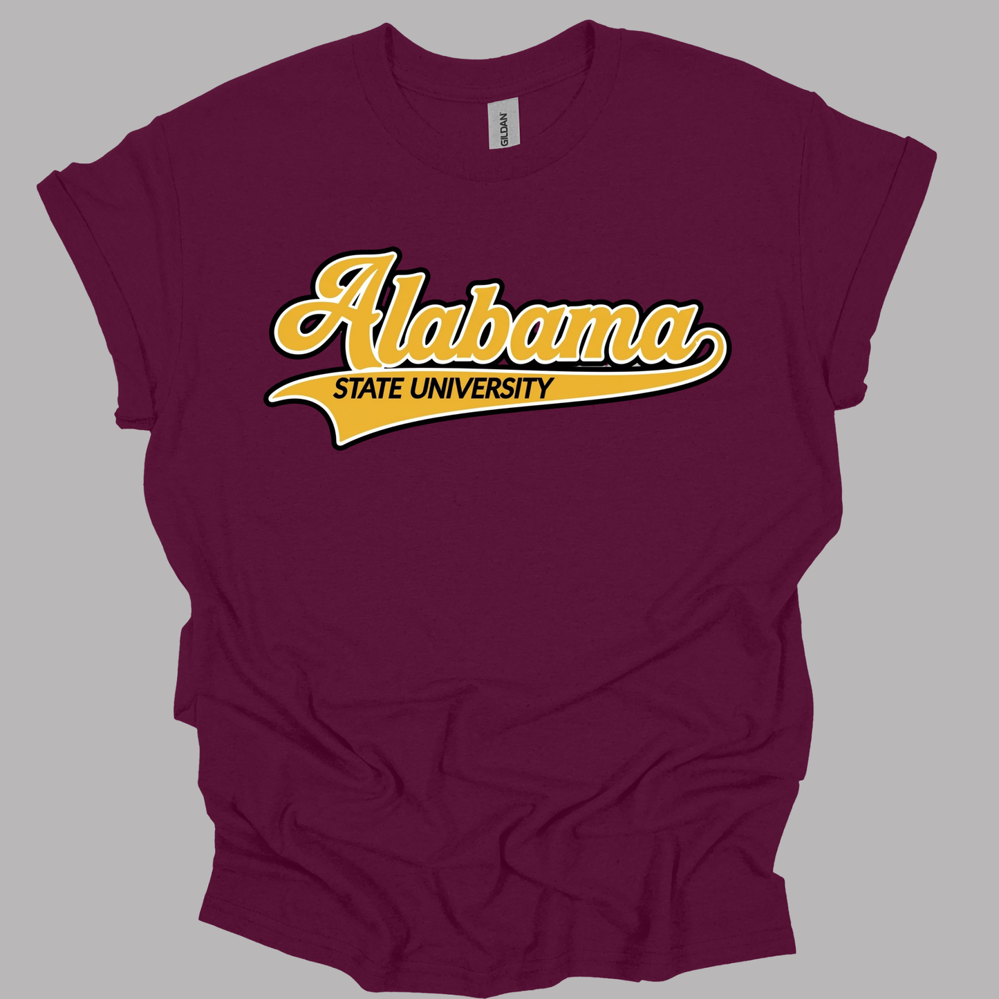 A maroon short-sleeve t-shirt with a yellow and white 'Alabama State University' graphic on the chest, displayed against a solid gray background.