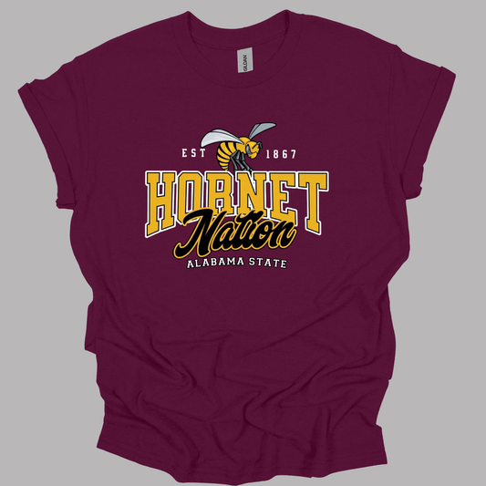 A maroon short-sleeve t-shirt with a graphic on the front that reads 'HORNET Nation ALABAMA STATE' in yellow and black, featuring a hornet illustration and 'EST. 1867'.