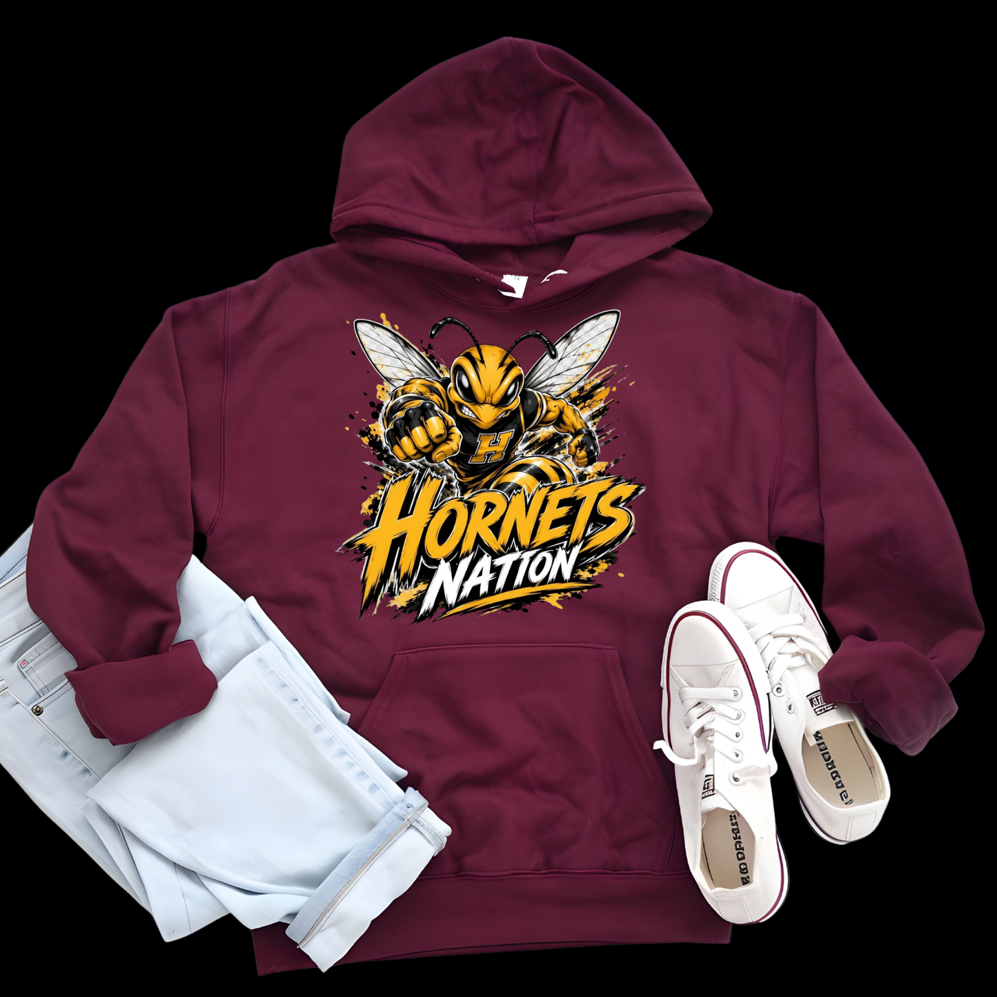 A maroon pullover hoodie with a large yellow and black hornet graphic and the words 'Hornets Nation' on the front, styled in a flat lay with light blue jeans and white sneakers on a black background.