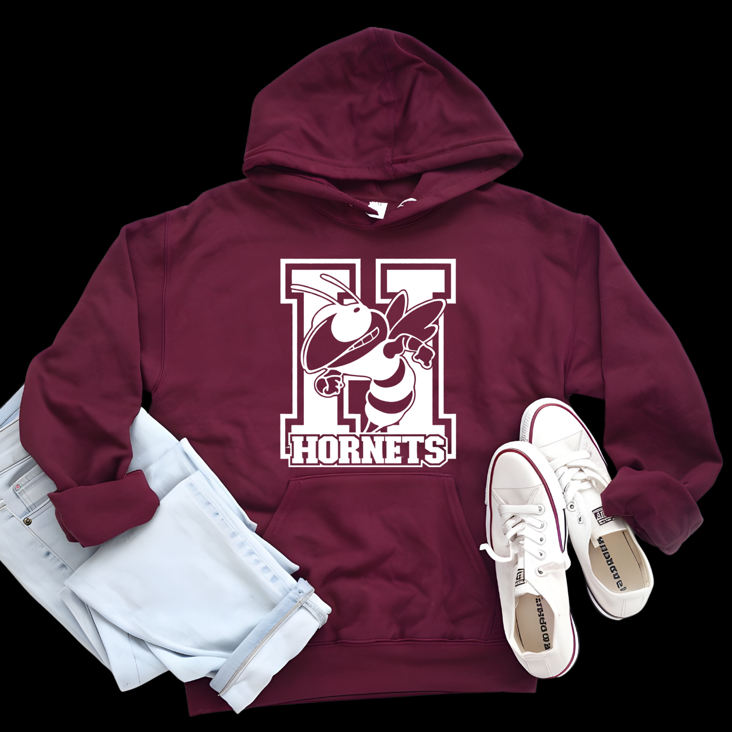 A maroon pullover hoodie with a large yellow and black hornet graphic and the words 'Hornets Nation' on the front, styled in a flat lay with light blue jeans and white sneakers on a black background.