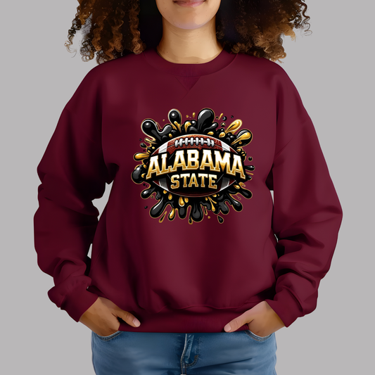 A woman wearing a maroon crewneck sweatshirt with a 'Hornet Nation Alabama State' graphic on the front, paired with blue jeans, set against a solid gray background.
