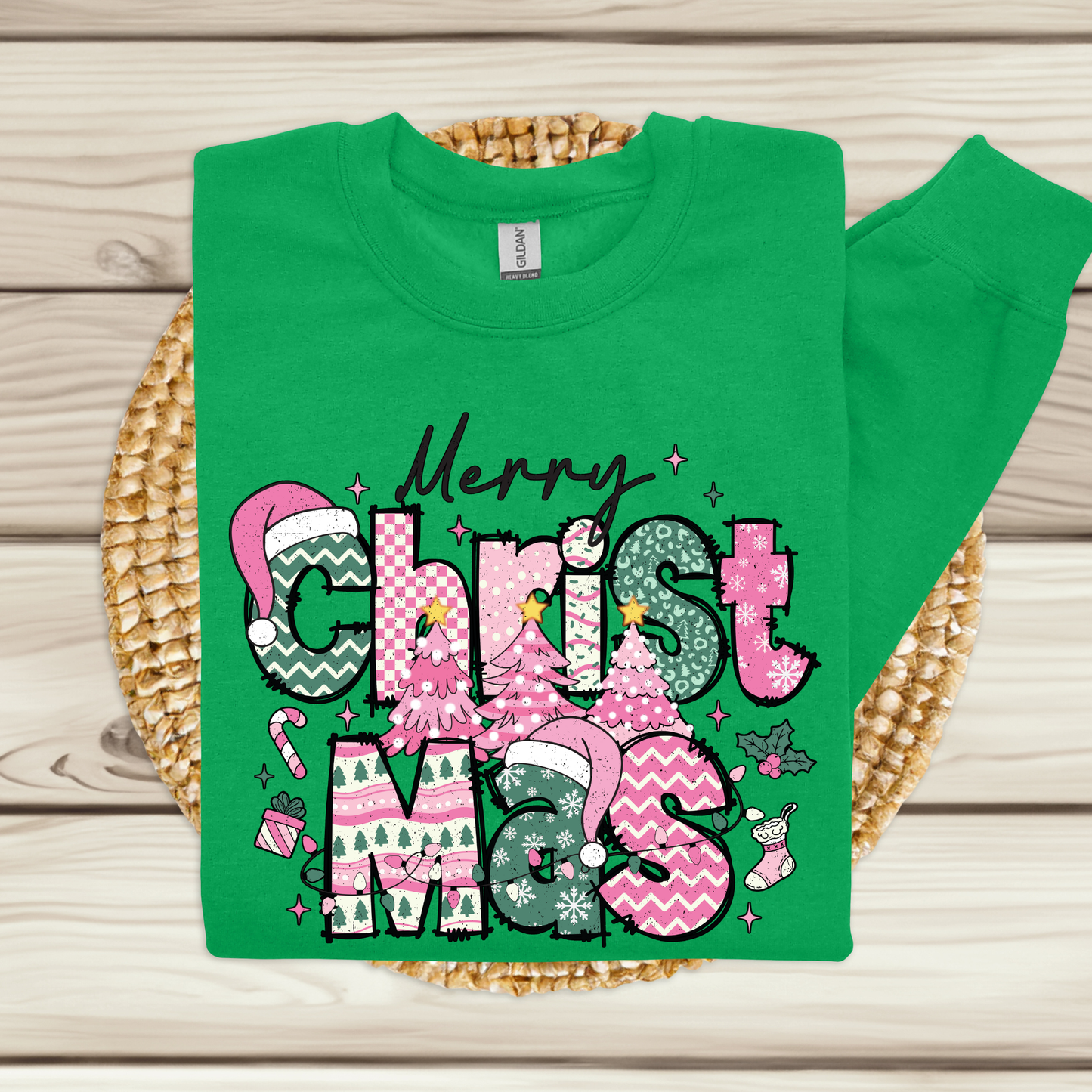 Green t-shirt with Christmas-themed text and graphics on a woven mat.