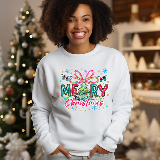 Person wearing a white sweatshirt with a colorful 'Merry Christmas' design, standing in a festive setting with a Christmas tree.