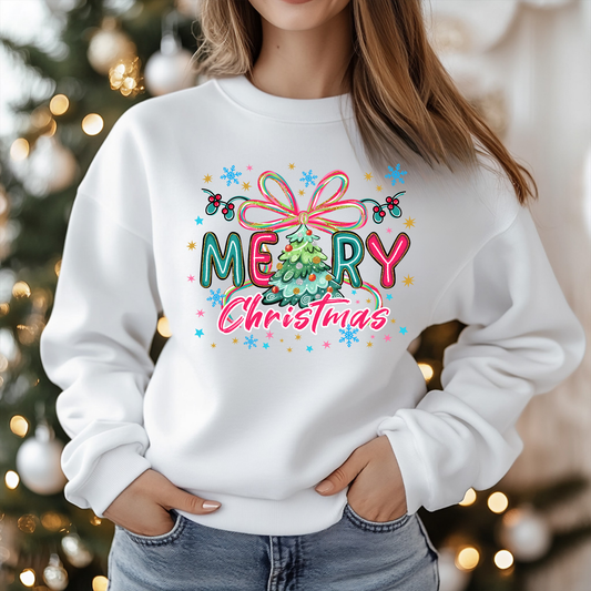 Person wearing a white sweatshirt with 'Merry Christmas' design in front of a decorated Christmas tree.