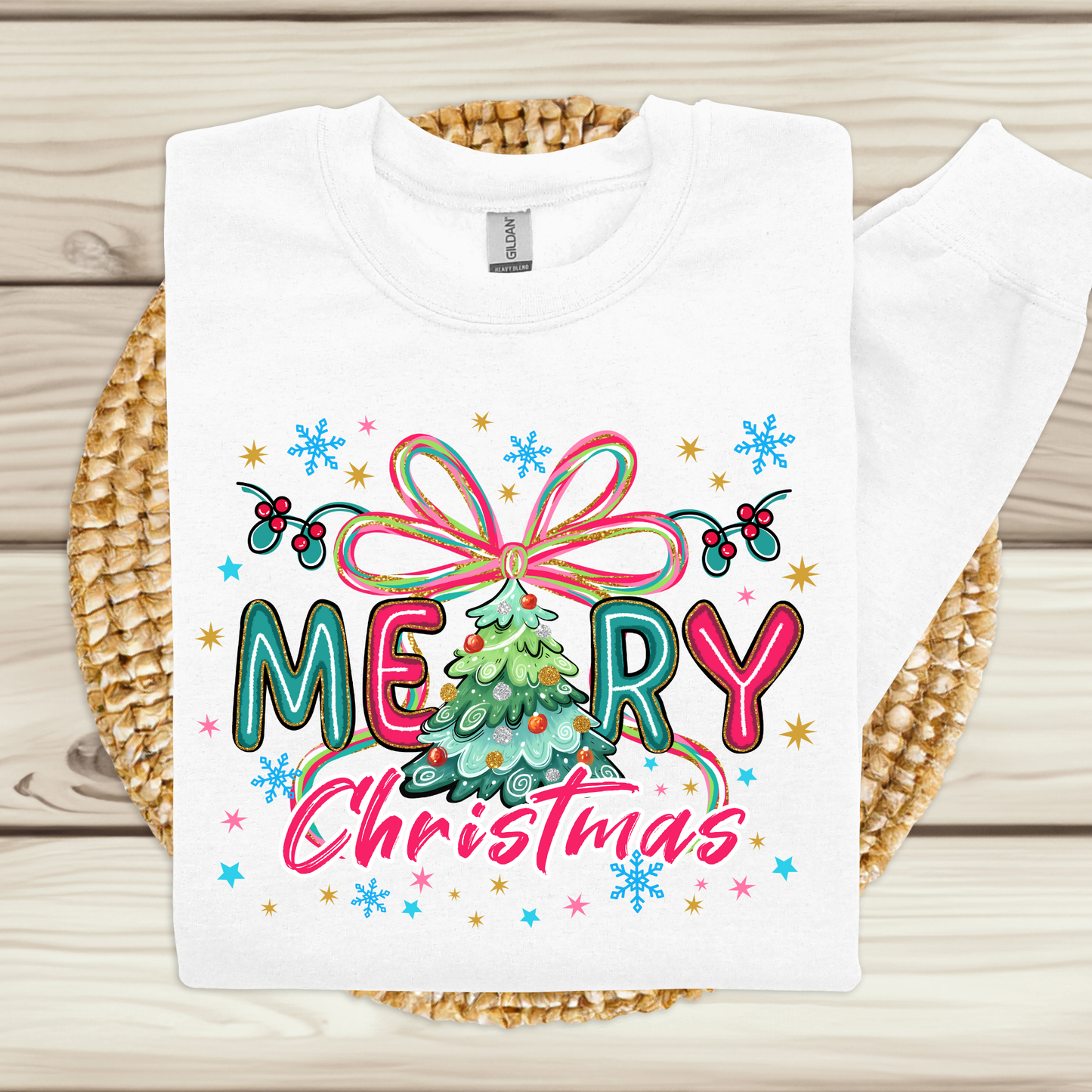 White t-shirt with colorful 'Merry Christmas' design on a woven mat.