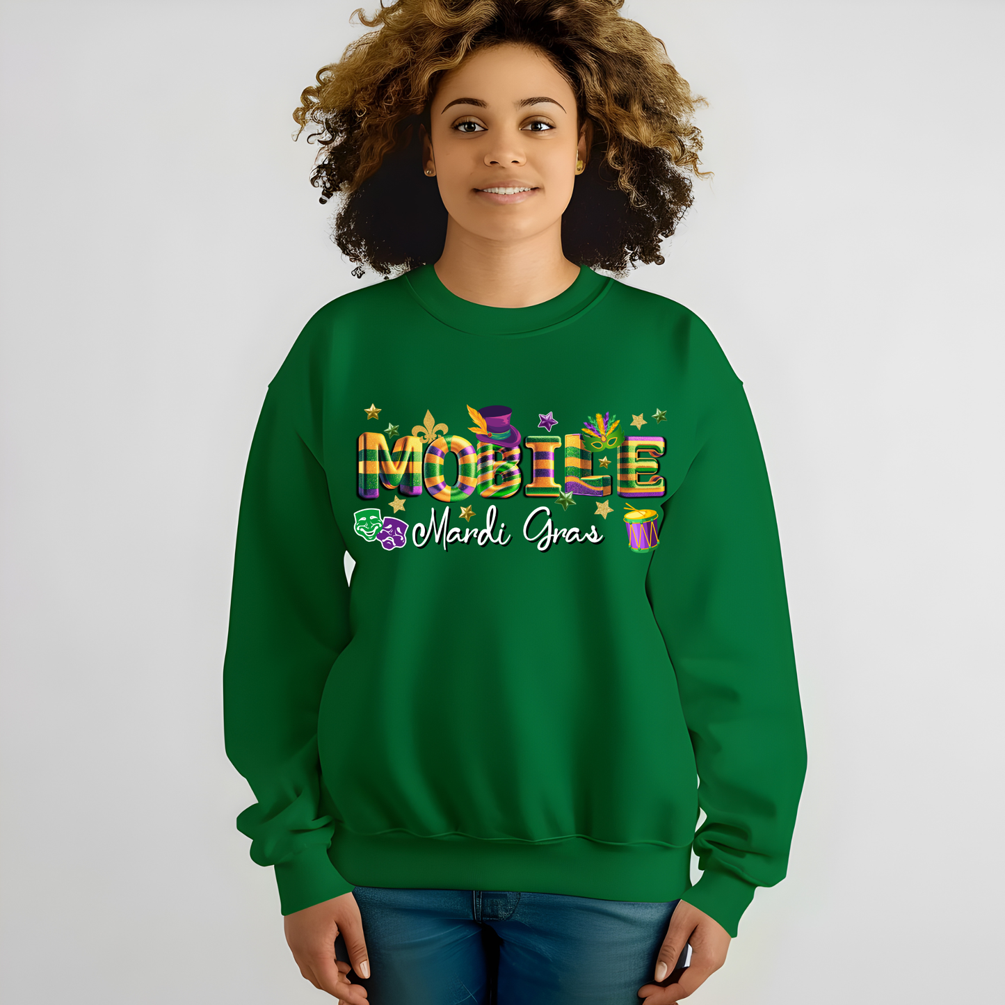 Person wearing a green sweatshirt with 'Mardi Gras' text and decorations on a plain background