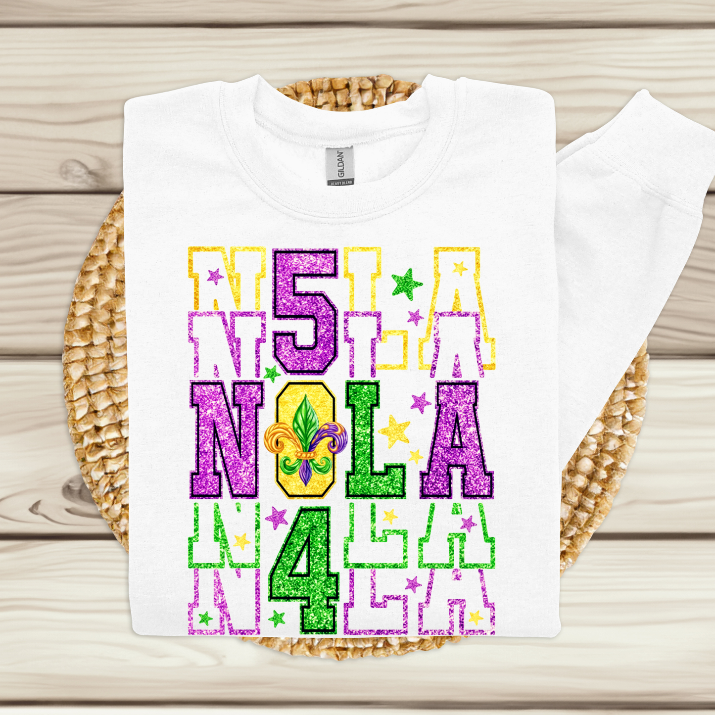 White t-shirt with colorful '5 LA NOLA 4' design on a woven mat.