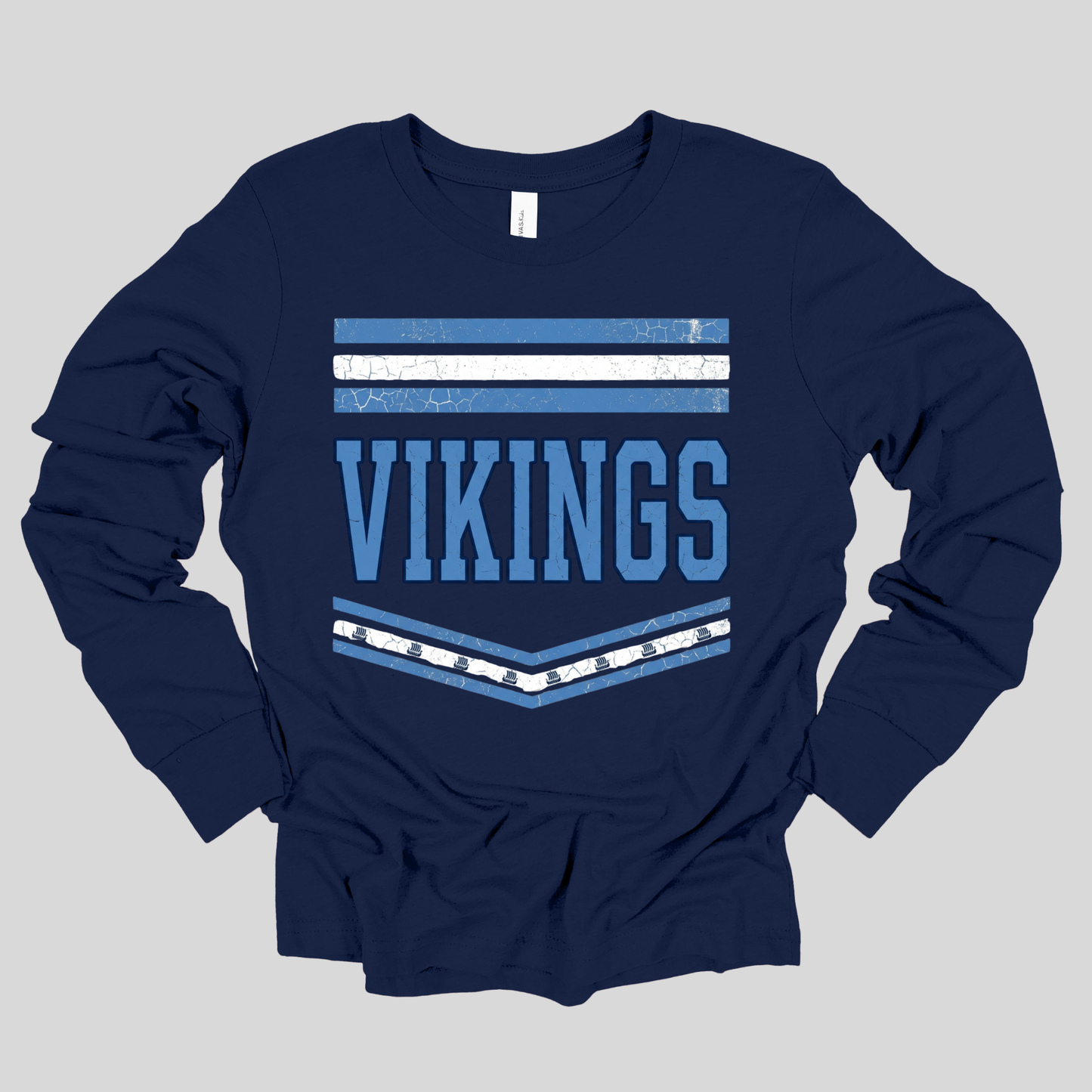 A navy blue long-sleeve t-shirt with a distressed graphic on the chest featuring the word 'VIKINGS' in light blue block letters, flanked by horizontal stripes in light blue and white.
