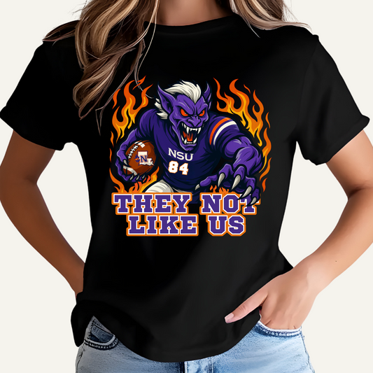 Black t-shirt with a graphic design of a creature holding a football and text 'THEY NOT LIKE US' on a white background. Northwestern Demons Game Day T-Shirt - Demons  "They Not Like Us"  Football Tee