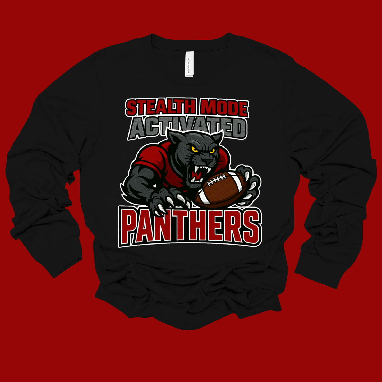 A black long-sleeve t-shirt with a graphic of a panther football player and the text 'STEALTH MODE ACTIVATED PANTHERS' on a solid red background.