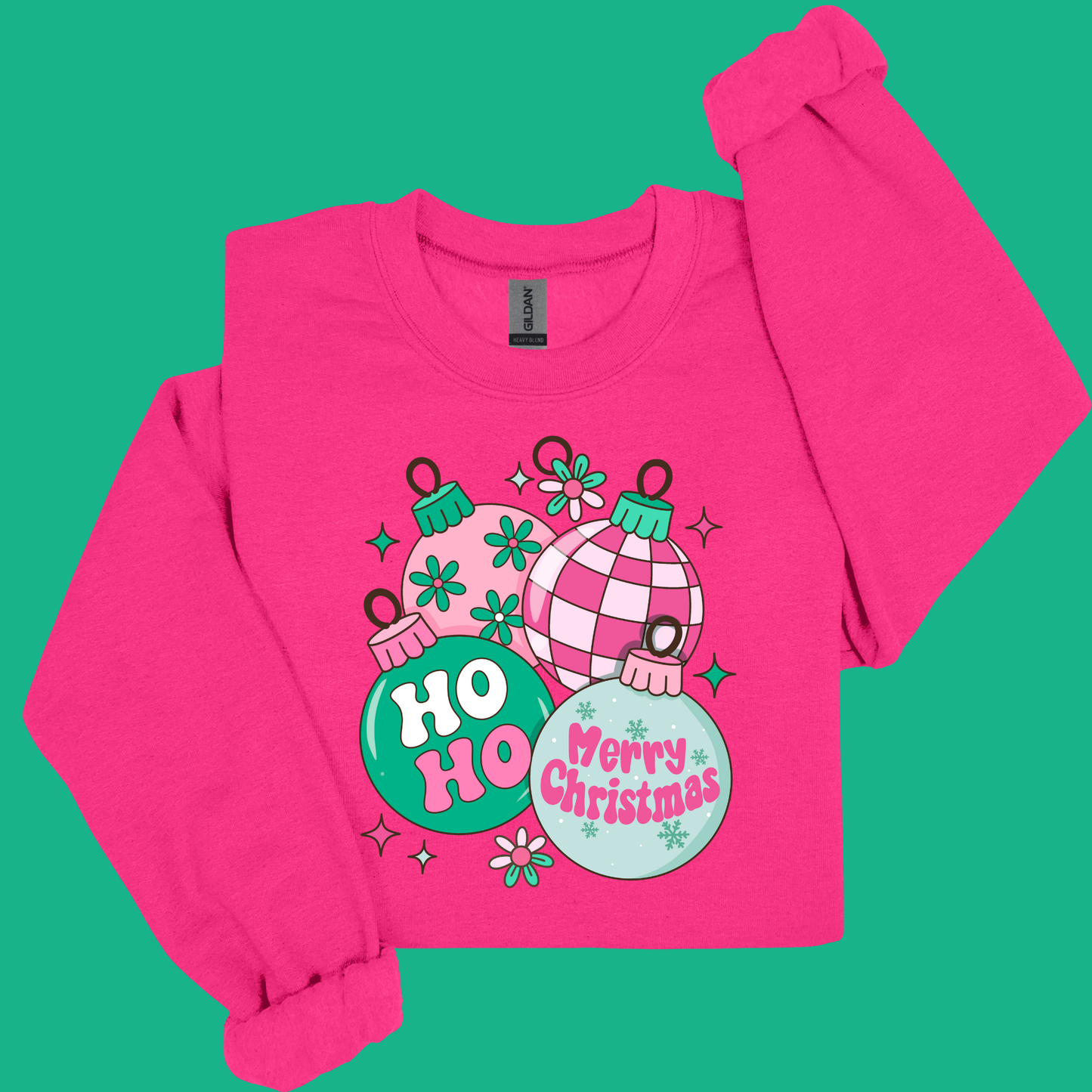 Pink long-sleeve shirt with Christmas-themed design on a green background