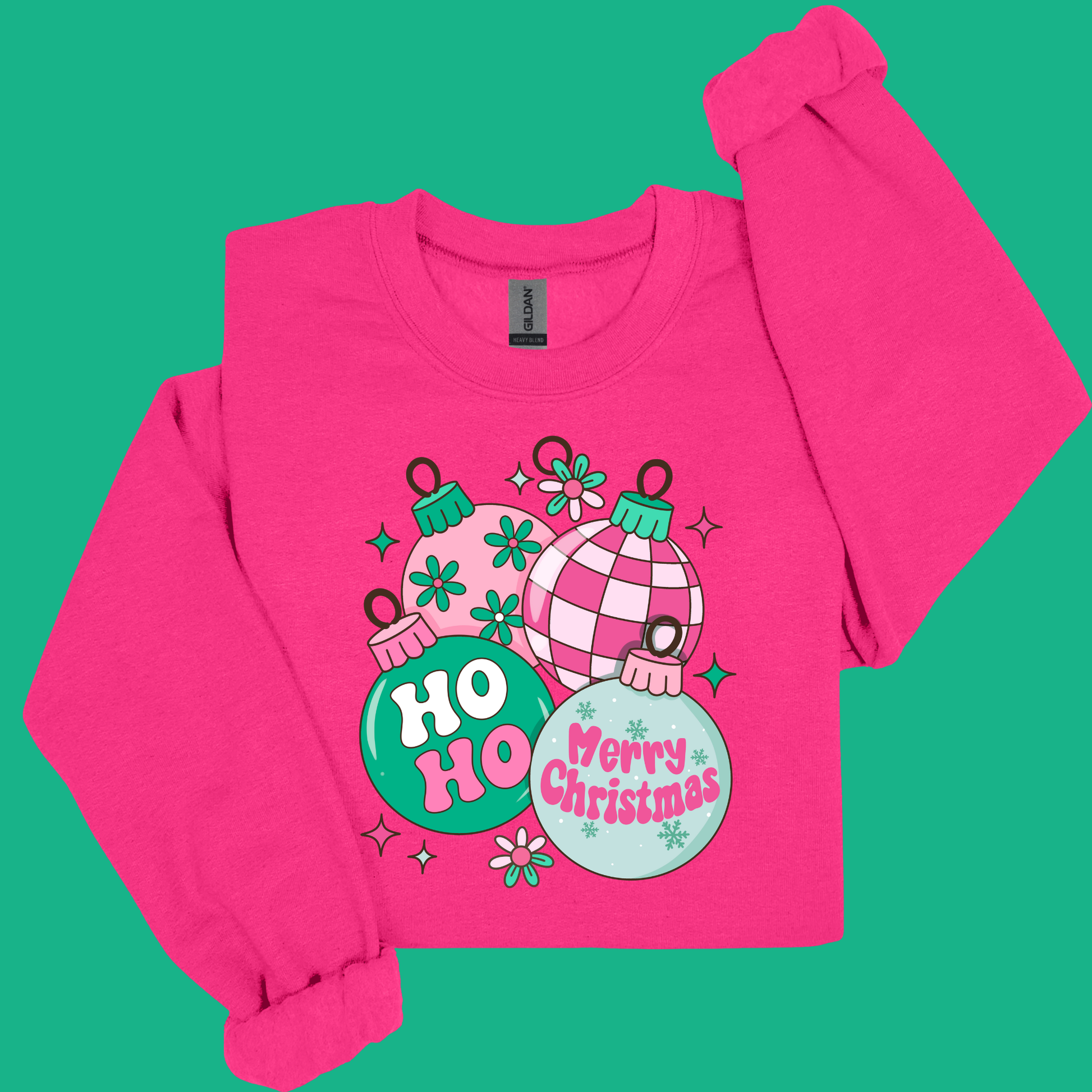 Pink long-sleeve shirt with Christmas-themed design on a green background