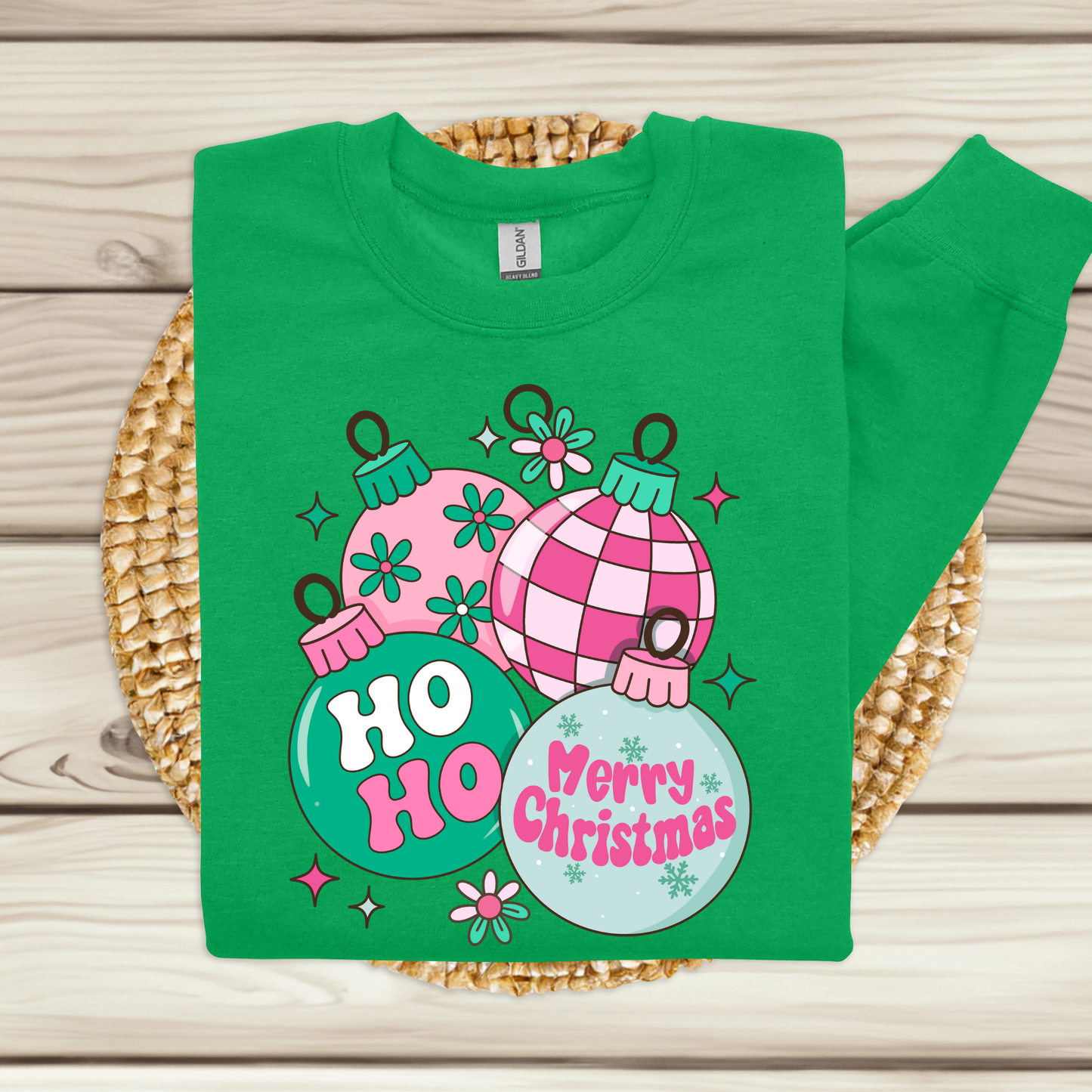 Green t-shirt with Christmas-themed design on a woven mat
