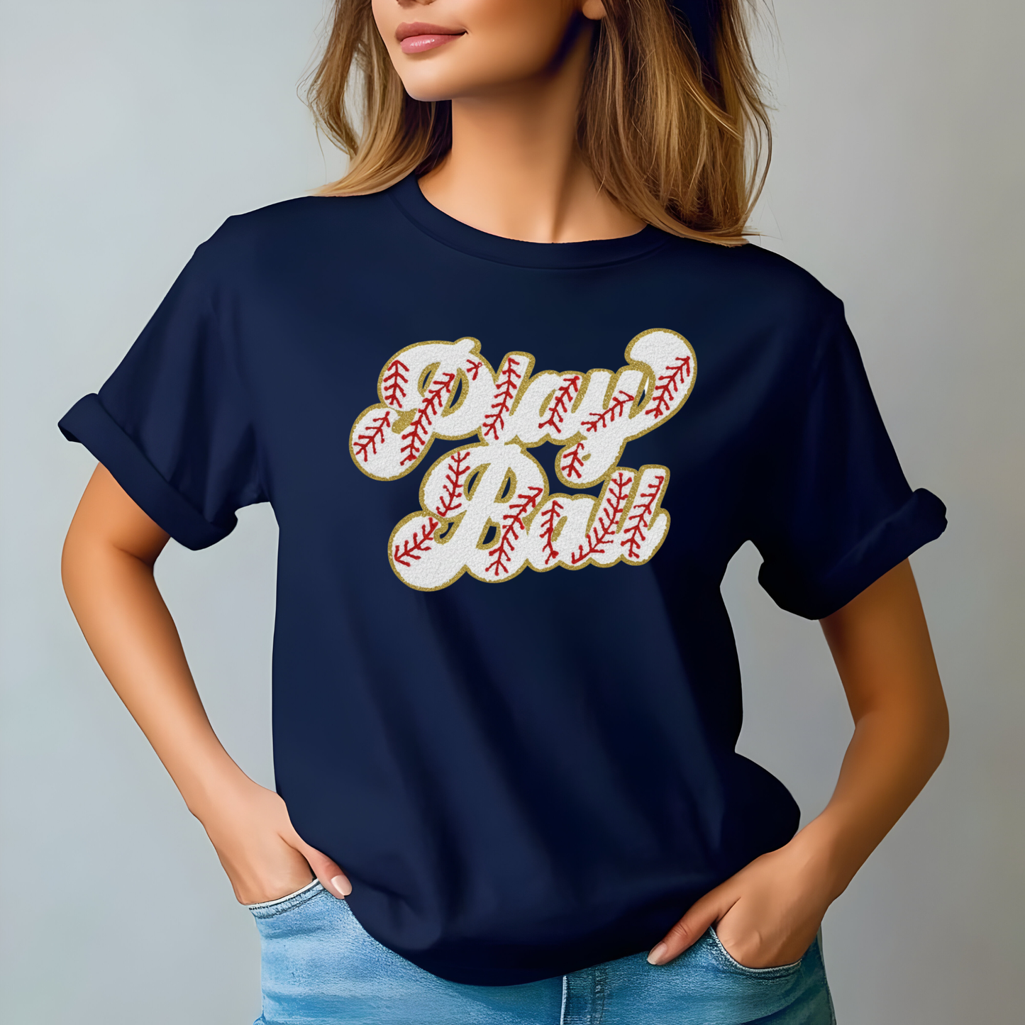 Person wearing a navy blue t-shirt with 'Play Ball' text design on a plain background